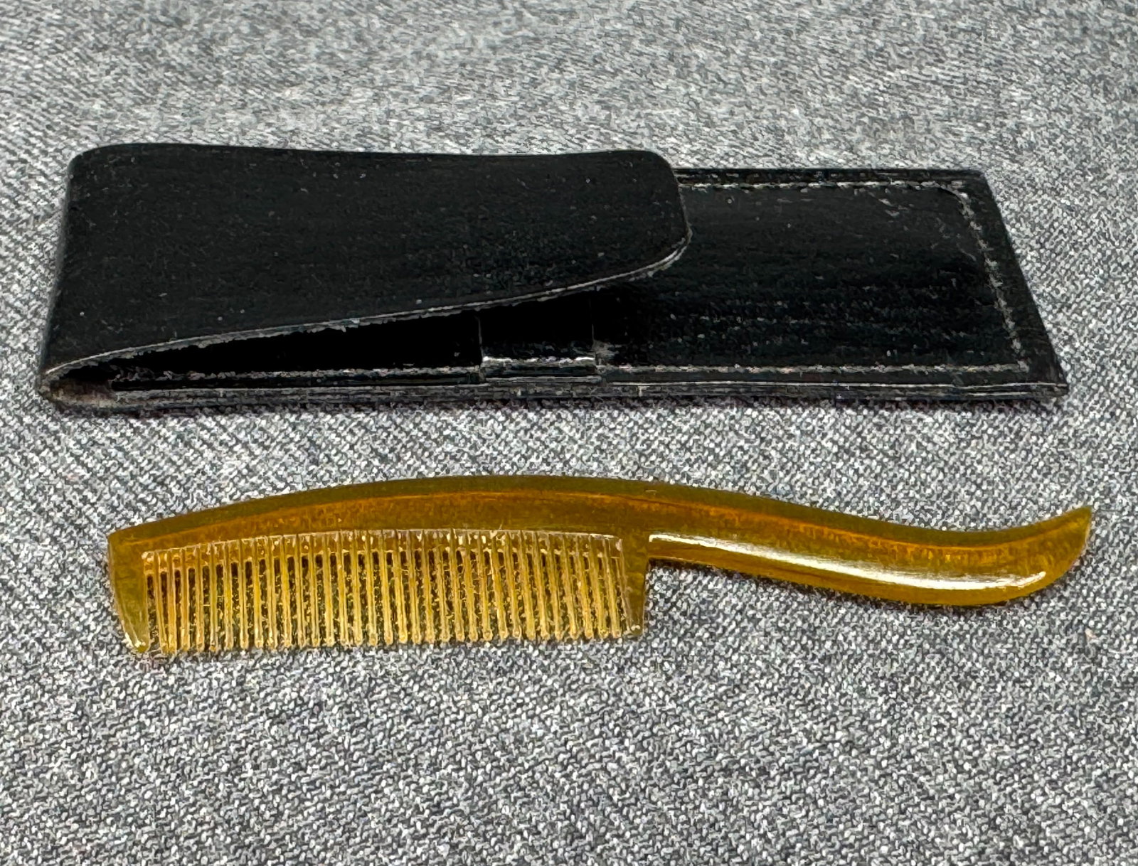 Vintage amber celluloid pocket mustache comb with case. *e: Vintage amber color celluloid pocket mustache comb. Simile black leather case. Unmarked. For measures please refer to the pictures that were taken with a measuring tape. Weight: 4 Grams. IN HOUSE FLAT