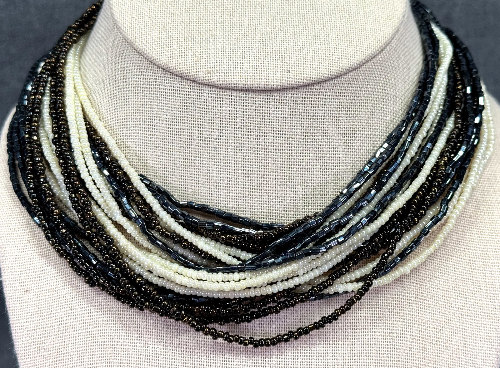 Vintage Pearly & Iridescent Black Seed Glass Beads Multi-Strand Necklace. *M: Vintage Pearly & Iridescent Black Seed Glass Beads Multi-Strand Necklace. Gold-Toned Jeweled Calsp.Unmarked. For measures please refer to the pictures taken with a measuring tape. Weight: 65 Grams. IN