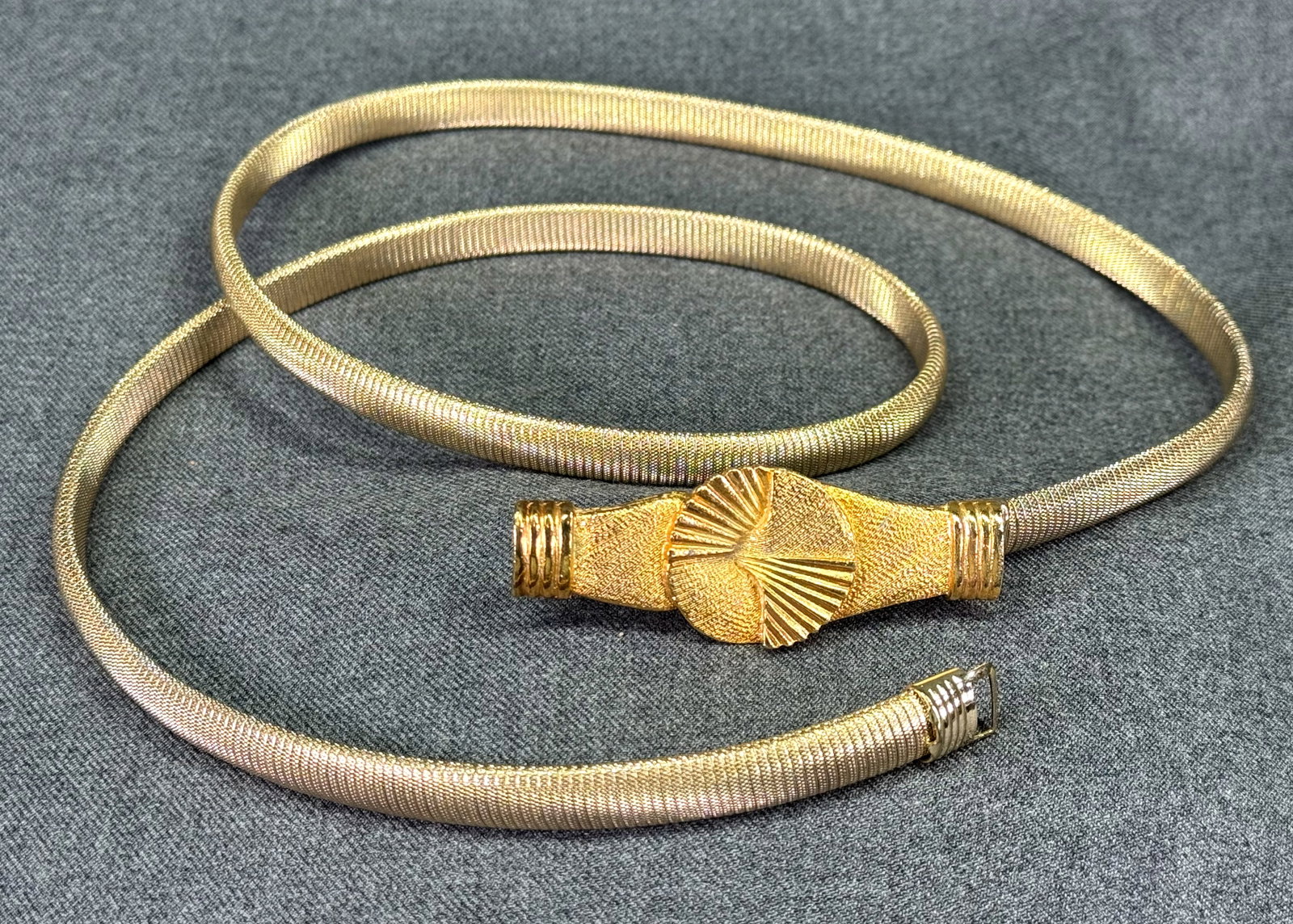 Vintage Stretch Textured Omega Chain Belt. Sunburst interlocking Buckle. Gold-toned. *L: Vintage Stretch Textured Omega Chain Belt. Sunburst interlocking Buckle. Gold-toned. Unmarked. Around 40 inches long unextended. For measures please refer to the pictures taken with a measuring tape. 