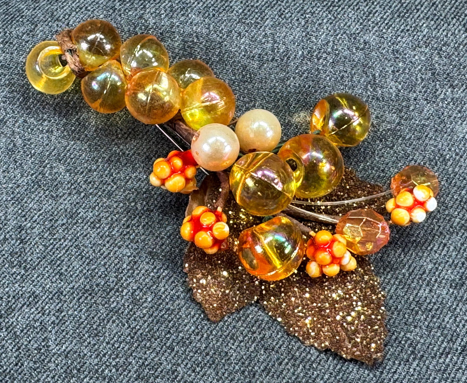 Vintage fall colors assorted beads glitter leaf brooch pin: Vintage fall colors assorted beads glitter leaf brooch pin. Unmarked. For measures please refer to the pictures taken with a measuring tape. Weight: 16 Grams. IN HOUSE FLAT SHIPPING & HANDLING COST WI