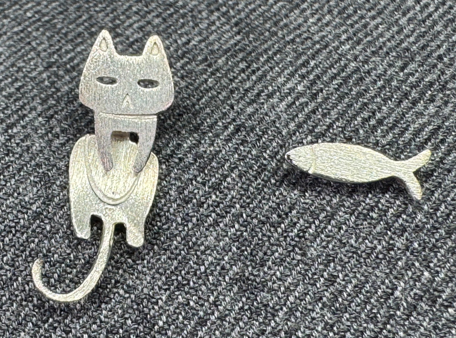 Artisan Sterling Kinetic Cat Fish Earrings. *n: Stud earrings featuring a whimsical cat and fish design. The cat earring is constructed in two detachable pieces, allowing the body and tail section to swing freely behind or in front of the earlobe f