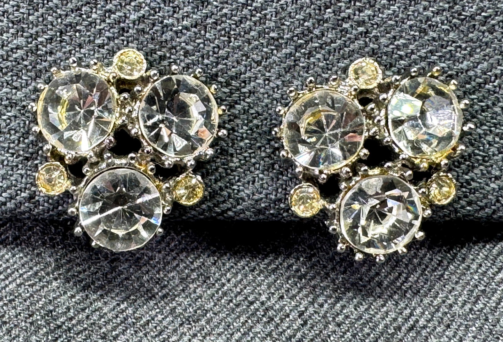 1970s Weiss Style Rhinestone Clip-On Earrings. *n: Vintage 1970s Weiss Style Clear & Yellowish Rhinestone Cluster Clip On Earrings Silver Tone. Unmarked. For measures please refer to the pictures taken with a measuring tape. Weight: 15 Grams. IN HOUSE