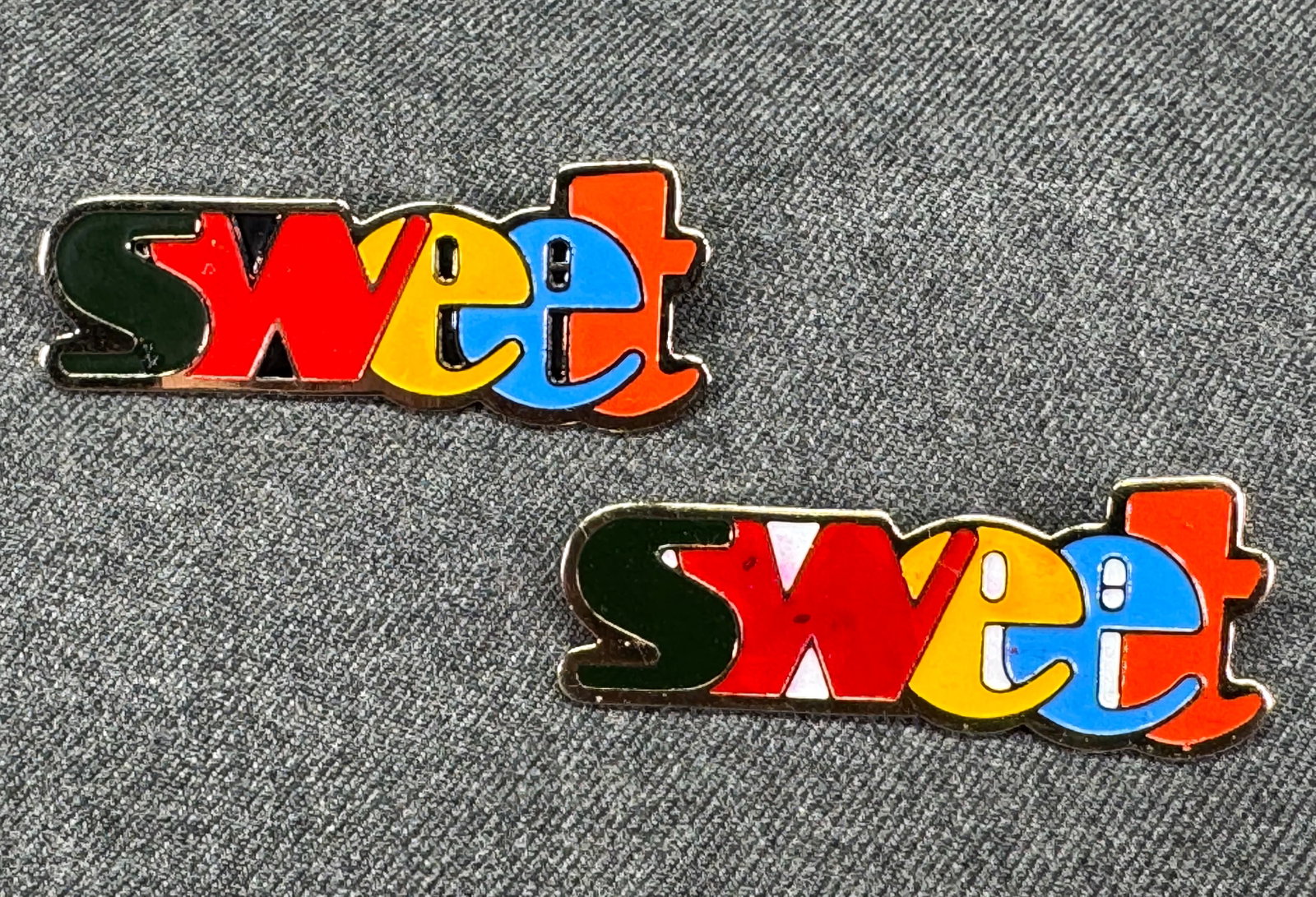 Vintage 1970s Pop Enamel Sweet Pins. (2) *n: Vintage 1970s Pop Culture Badges "Sweet" Enamel Brooches Pins. Gold-tone. Lot of 2. Unmarked. For measures please refer to the pictures taken with a measuring tape. Weight: 14 Grams. IN HOUSE FLAT SHI
