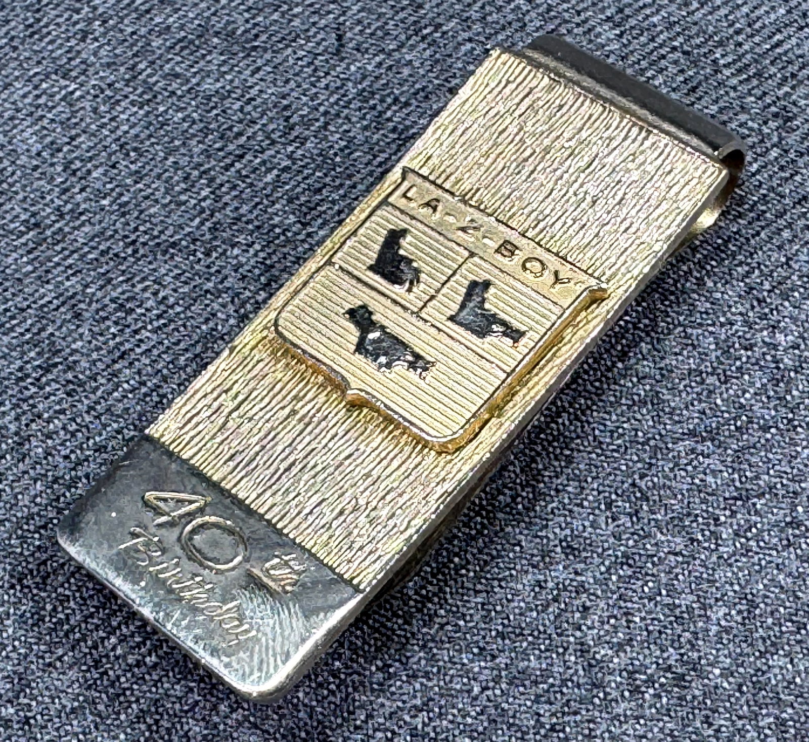 1960s La-Z-Boy Recliner-Rocker Promo Money Clip. *n: Vintage 1967 La-Z-Boy Recliner-Rocker Logo 40th Anniversary Promo Money Clip. Gold-tone. Unmarked. For measures please refer to the pictures taken with a measuring tape. Weight: 20 Grams. IN HOUSE FLA