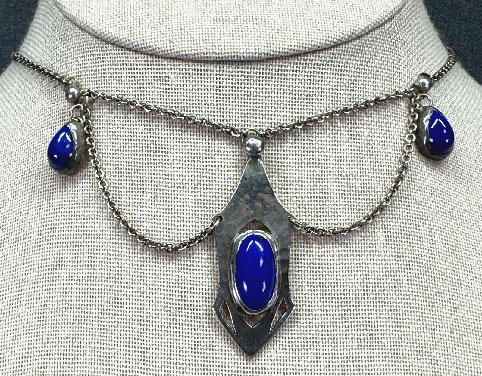Arts & Crafts Hammered Sterling Silver Festoon Necklace. Lapis Lazuli Cabs. *g: Arts & Crafts Hammered Sterling Silver Festoon Necklace with Lapis Lazuli Cabochons. Marked on clasp. For measures please refer to the pictures taken with a measuring tape. Weight: 13.98 Grams. IN HOU