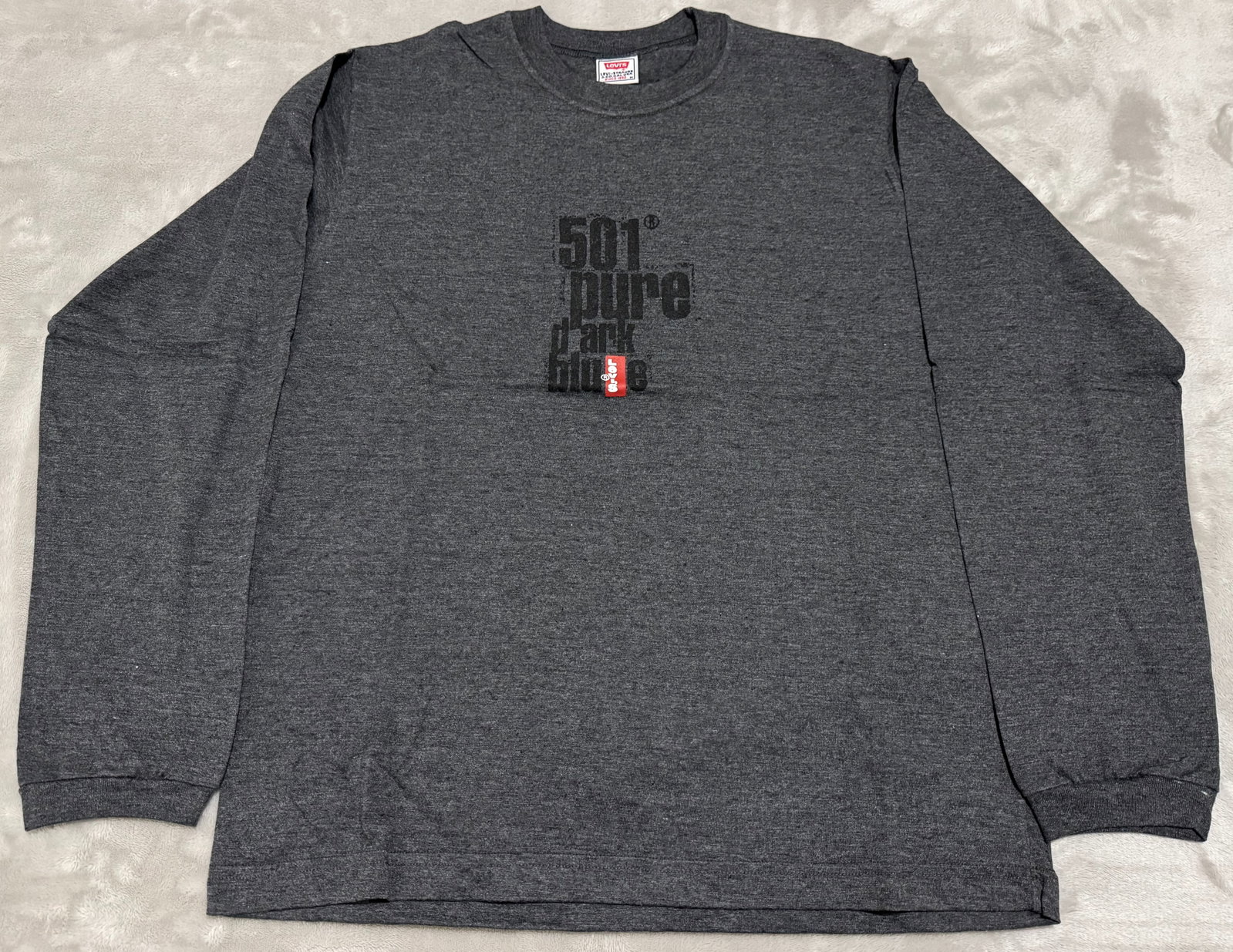 NOS 90s Vintage Levis Grey 501 Pure Dark Blue Long Sleeve T-Shirt: Unused Vintage 1990s Levi Strauss & Co. long-sleeve crewneck t-shirt. Features a centered block graphic reading 501 pure dark blue" in a distressed black or dark font overlaying a miniature vertical r