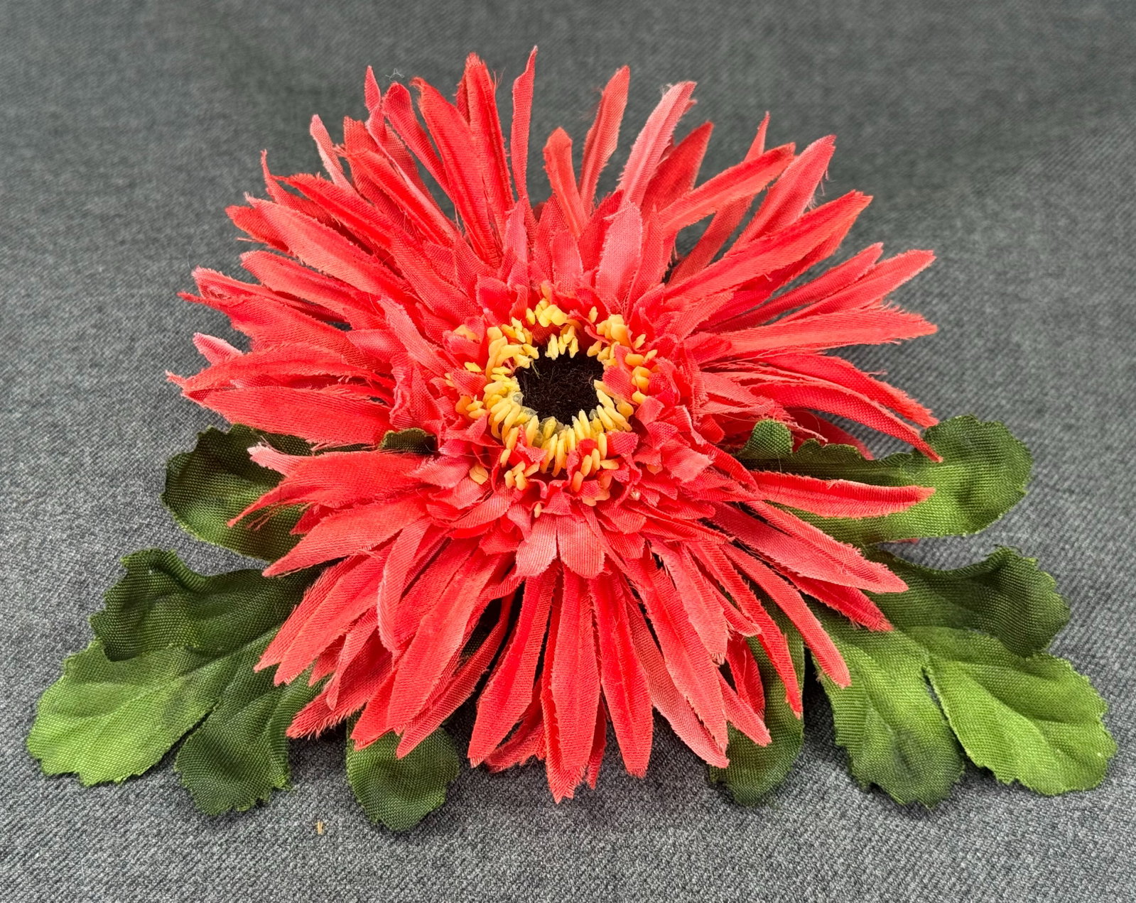 Vintage Fabric Spider Gerbera Daisy Brooch Pin. *p: fabric spider gerbera daisy brooch pin featuring red textured petals, green faux foliage, and a plastic backing. Unmarked. For measures please refer to the pictures taken with a measuring tape. Weight
