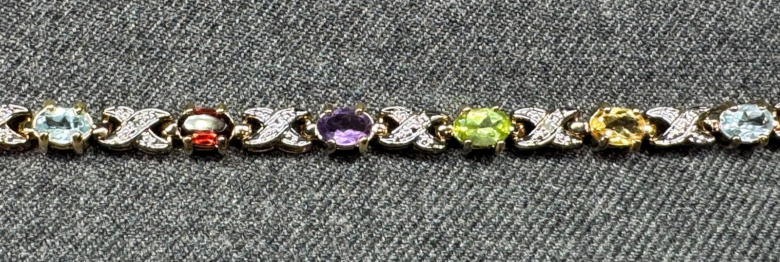 PAJ Designer Sterling Silver Vermeil Multi Gemstone XO Tennis Bracelet. #s: Vintage gold-over-sterling silver (vermeil) line tennis bracelet by PAJ (Prime Art Jewelry). Features an alternating polished "XO" link design bezel and prong-set with oval-cut multi-gemstones, includ
