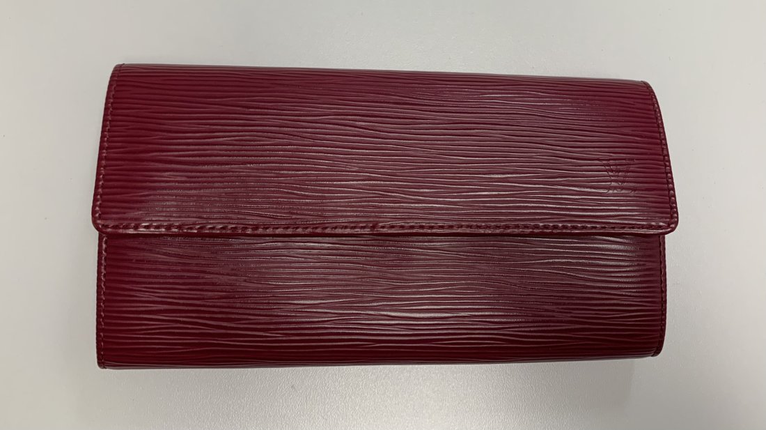 LOUIS VUITTON EPI SARAH WALLET: LOUIS VUITTON EPI SARAH WALLET WITH A UNIQUE DARK PINK/ RED COLOR. THIS STUNNING WALLET HAS 10 CREDIT CARD SLOTS, ONE ZIPPERED POCKET IN THE CENTER AND 2 OPEN POCKETS. THE WALLET MESURES AT 7.5" X 4".