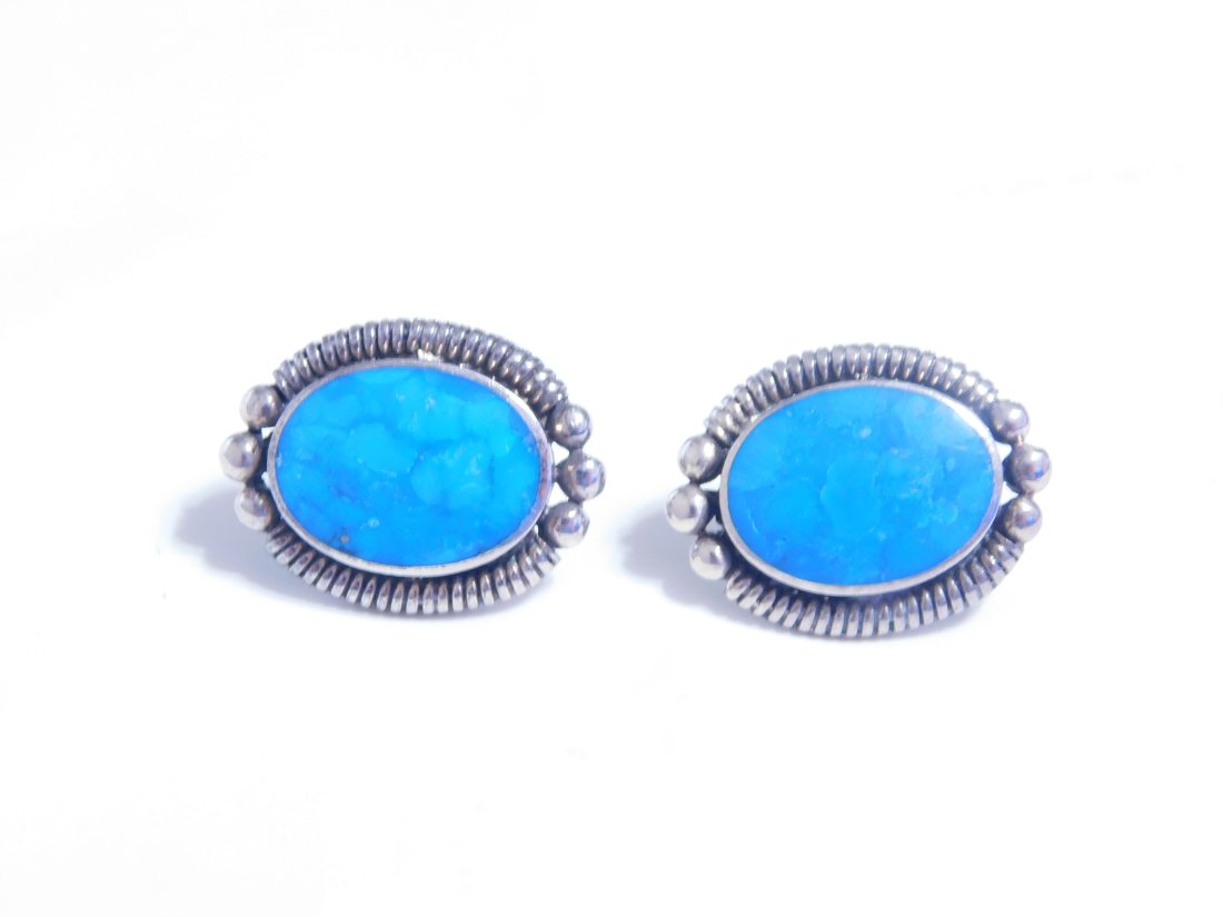 Beautiful Sterling Silver Native American Oval Blue Turquoise Earrings: These beautiful Native American earrings feature oval-shaped natural blue turquoise stones, set in sterling silver with a bezel setting style. The earrings have a stud style and are designed for women