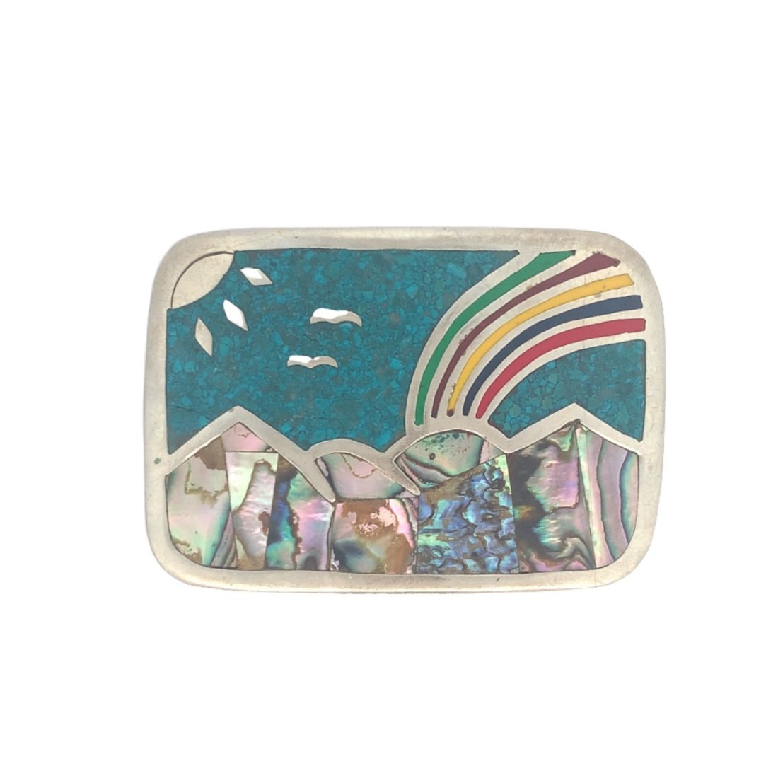 Nickel Silver Mexican Inlayed Belt Buckle: This 3" x 2.5" nickel silver belt buckle features a crushed turquoise sky with 2 silver inlay birds and sun along with an enamel inlay rainbow with abalone inlay mountains at the bottom of the buckle.