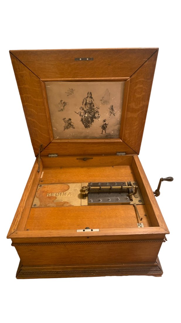 ANTIQUE REGINA MUSIC BOX c 1896: Antique Oak Case Regina Music Box c 1896. This Is the 15 1/2" Disk Double Comb Model. All teeth intact. Original Lithograph in lid. Original crank. Comes With 33 Disks. Not running. missing 1 foot. Ap