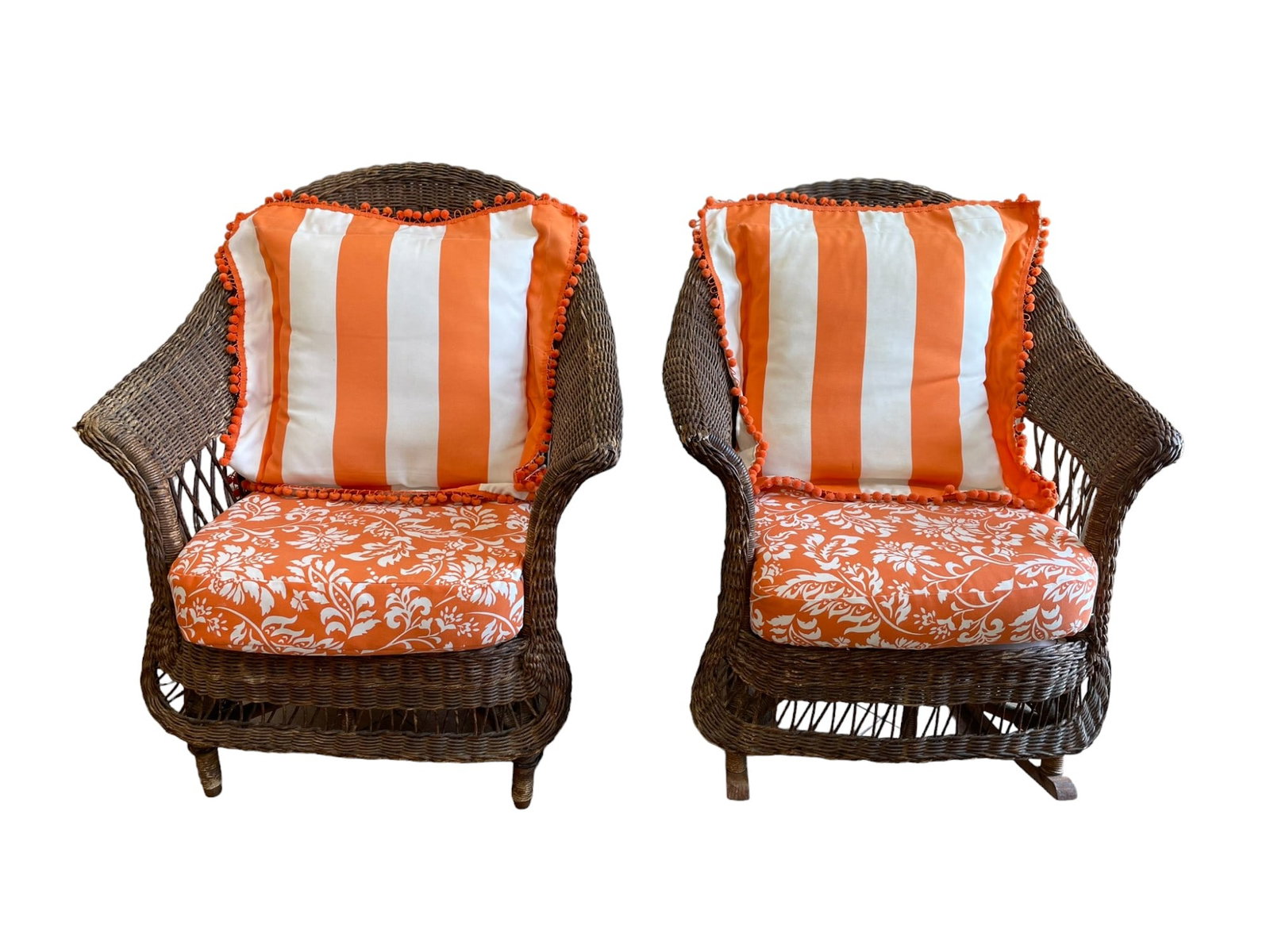 2 ANTIQUE AMERICAN WICKER ARM AND ROCKING CHAIR: Antique American Wicker Armchair 29"x20"x34" and Rocking Chair 37"x28"x34".. Orange and white Upholstery and Pillows.