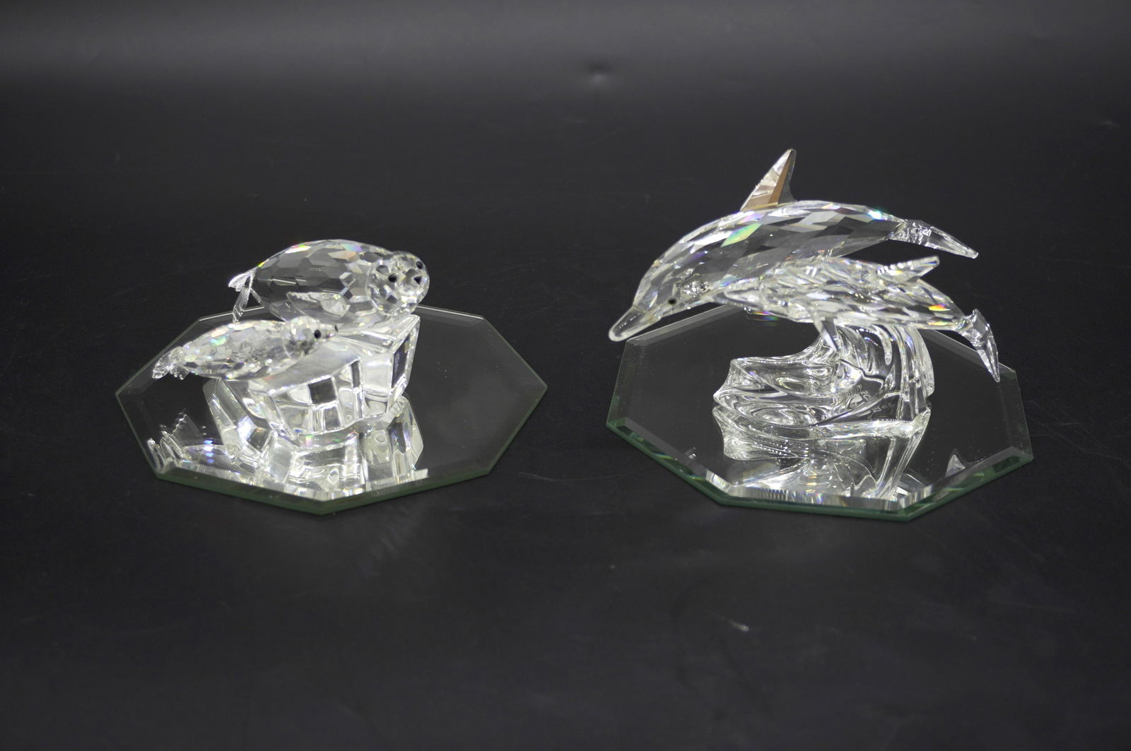PAIR RARE SWAROVSKI SCS CRYSTAL FIGURINES: Pair of Rare Swarovski SCS Crystal Figurines, Dolphins and Seals. Come with Mirrored Display Trivets. Both signed on base. Dolphins measure 5" x 3" x 2" and seals measure 3.75" x 2.5" x 2.25", total l