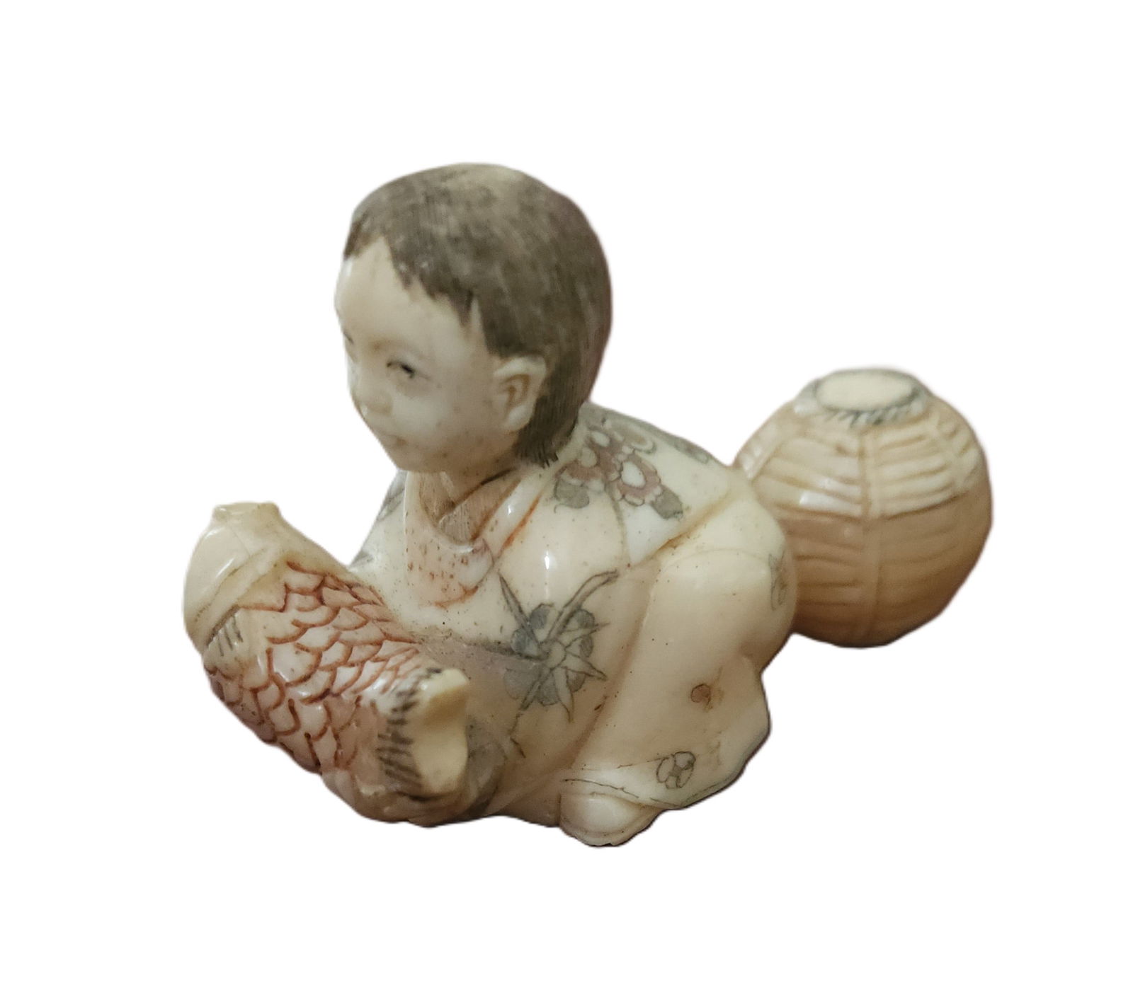 SIGNED ANTIQUE BONE JAPANESE NETSUKE FISHERMAN: Antique Japanese carved bone netsuke of a seated man with a fish and basket. Artist signed. With Himotoshi (two holes) used for the cord to attach the Netsuke to the obi. Measures 2 1/2". Weight 1.8 o