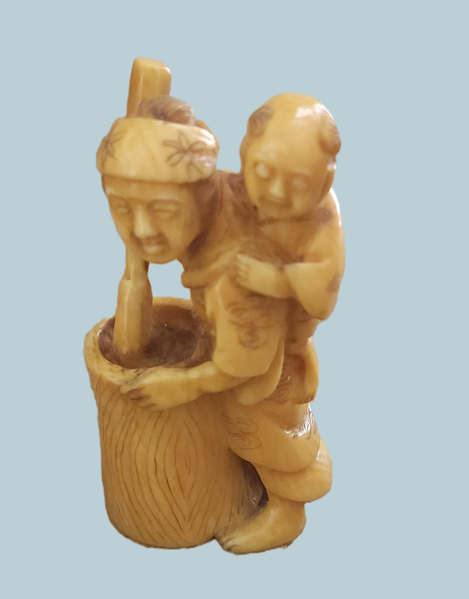 SIGNED ANTIQUE JAPANESE BONE NETSUKE MOTHER & CHILD: Antique Japanese carved bone netsuke of a mother and child. Artist signed. With Himotoshi (two holes) used for the cord to attach the Netsuke to the obi. Measures 2 1/4". Weight 1 oz.