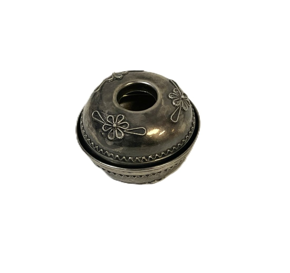 STERLING SILVER TRAVELING CANDLESTICK: Antique Sterling Silver Traveling Candlestick. Filigree flower accents. The two halves fit together to form a compact round shape for travel.. Measures 2 1/2"x1.75". Approximate silver weight 56 grams