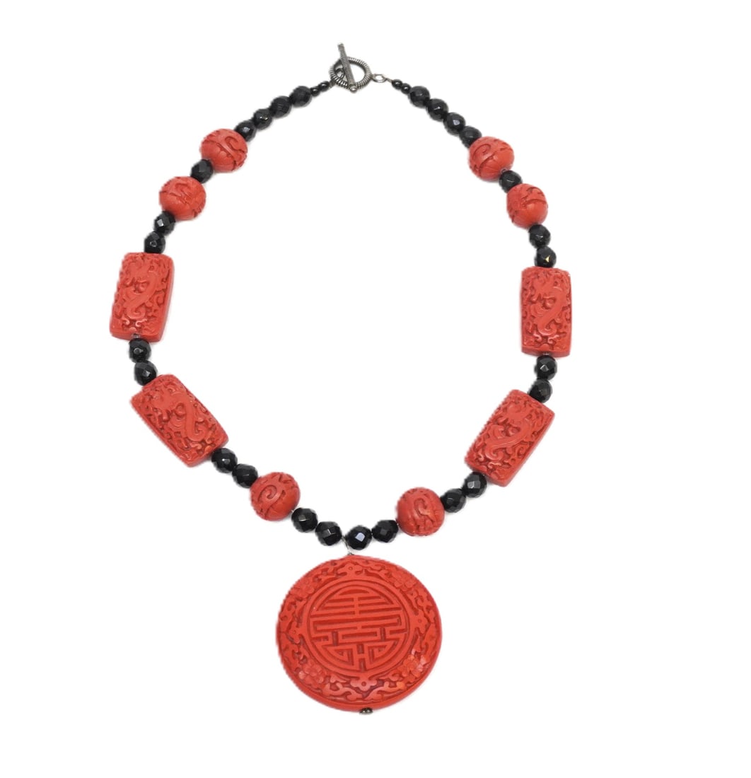 CARVED CINNABAR BEADED NECKLACE: Carved Cinnabar Beaded Necklace. Measures 19" in length. Weighs 3.2 oz.