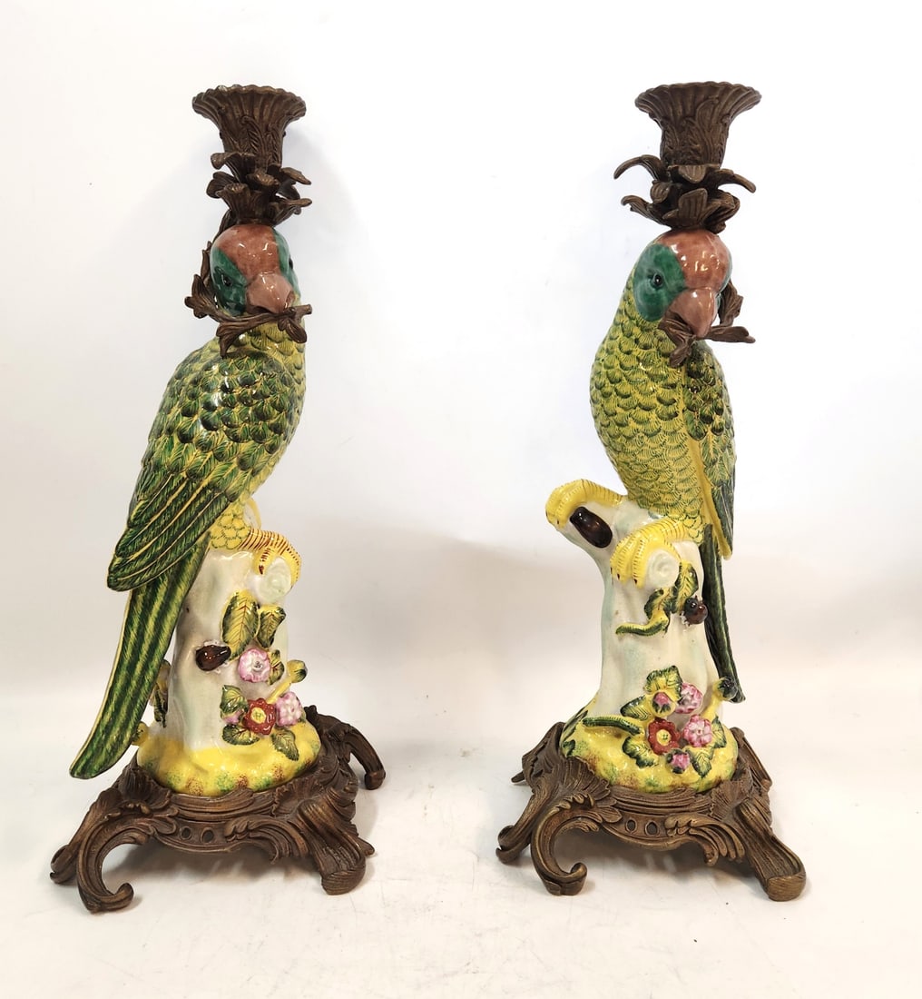 PAIR PORCELAIN AND BRONZE PARROT CANDLESTICKS: Two beautiful porcelain and bronze impressive candle holders. Each depicts a parrot.on tree holding a branch. They measure 8"x8"x14 1/2". Weight 10 lbs. PROVENANCE: A private South Battery Charleston,