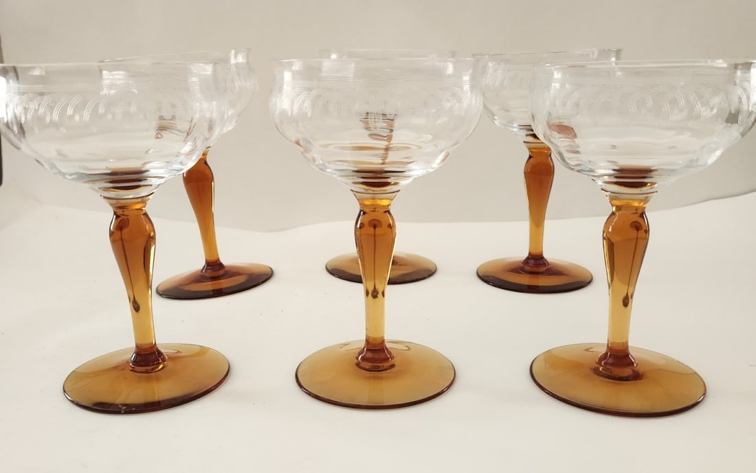 6 ELEGANT ERA ETCHED CHAMPAGNE COUPES AMBER STEM: Six (6) Elegant Era 1930-40s Etched Crystal Champagne Coupes. Ribbed Optic with etched laurel border pattern and amber stems. Each 3 1/4"x3 1/4"x5 1/4". Weight combined. 2 lbs. **In house shipping