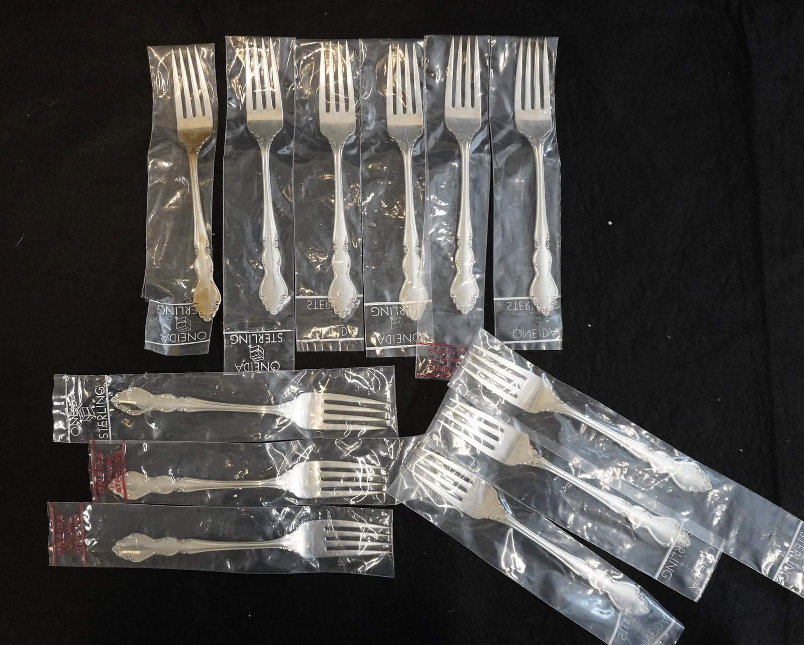 12 STERLING SILVER DOVER DINNER FORKS UNUSED: Twelve (12) Vintage Heirloom Sterling Silver "Dover" Pattern Dinner Forks by Oneida. Each 7 3/8". Still in the original packaging. Excellent condition, never used. Approximate silver weight 568 grams.
