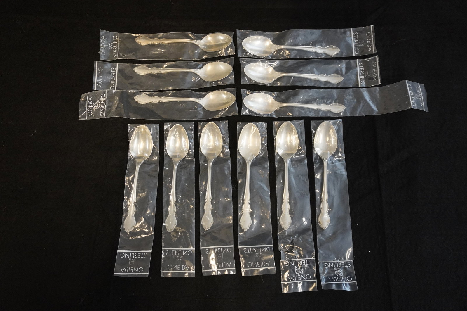 12 STERLING SILVER DOVER TEASPOONS UNUSED: Twelve (12) Vintage Heirloom Sterling Silver "Dover" Pattern Teaspoons by Oneida. Each 6". Still in the original packaging. Excellent condition, never used. Approximate silver weight 384 grams. **In