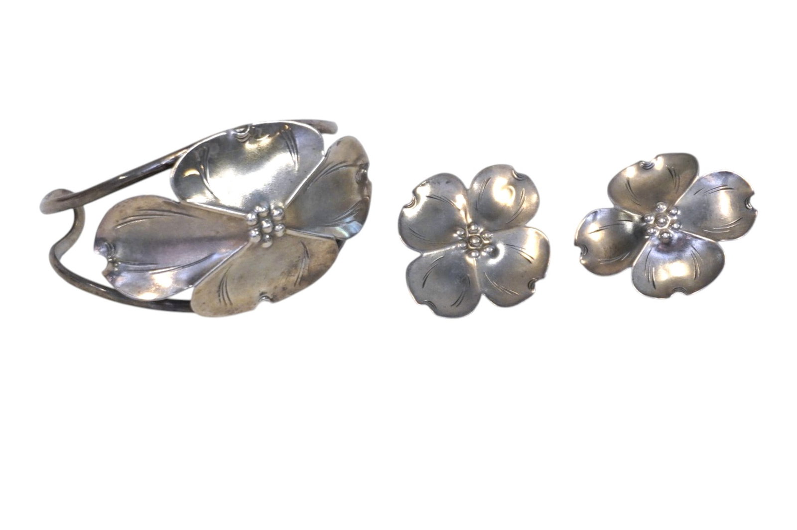 VINTAGE STERLING SILVER STUART NYE DOGWOOD DEMI PARURE: Vintage Stuart Nye 925 Sterling Silver Dogwood Cuff Bracelet and matching pierced Earrings. Bracelet opening 2 1/4". Approximate siler weight 22 grams. **In house shipping available on this lot** If y