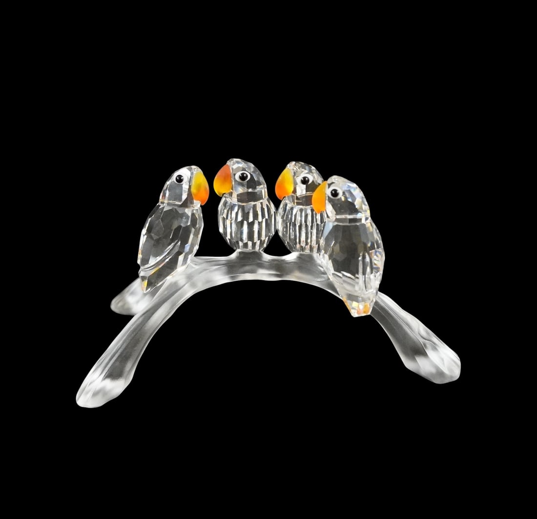 SWAROVSKI CRYSTAL BABY LOVEBIRDS "FEATHERED BEAUTIES" COLLECTION: Adorable Swarovski crystal figurine titled Lovebirds Baby, item number 199123. Features four faceted clear crystal birds with bright orange beaks and jet black eyes, perched on a frosted crystal branc