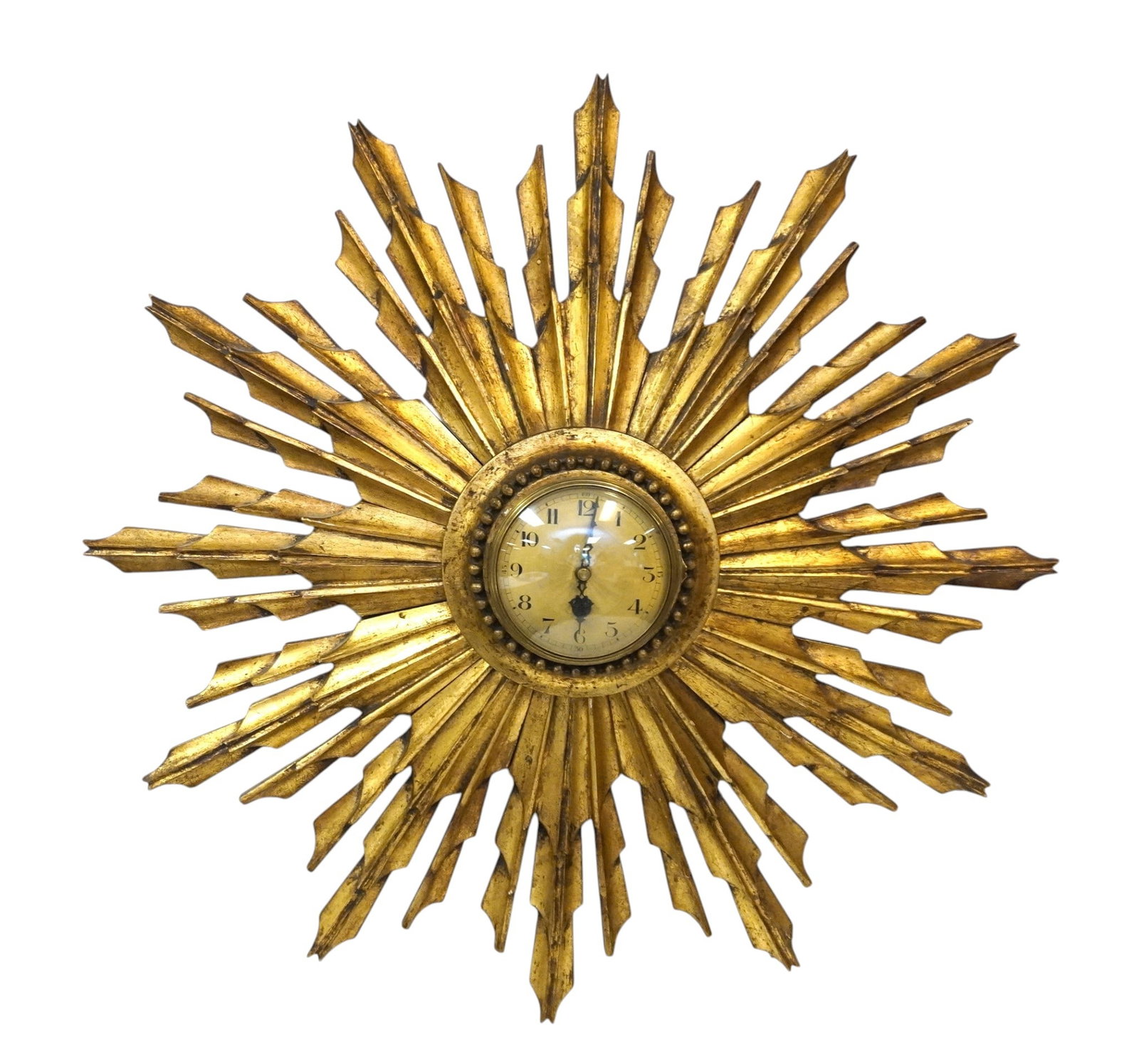 MID CENTURY GILTWOOD SUNBURST CONVEX WALL CLOCK: Hollywood Regency Mid Century Giltwood Sunburst Clock second quarter 20th century, with carefully detailed carved "rays", the works set into a cove-carved bezel, trimmed with beading, the dial likely 