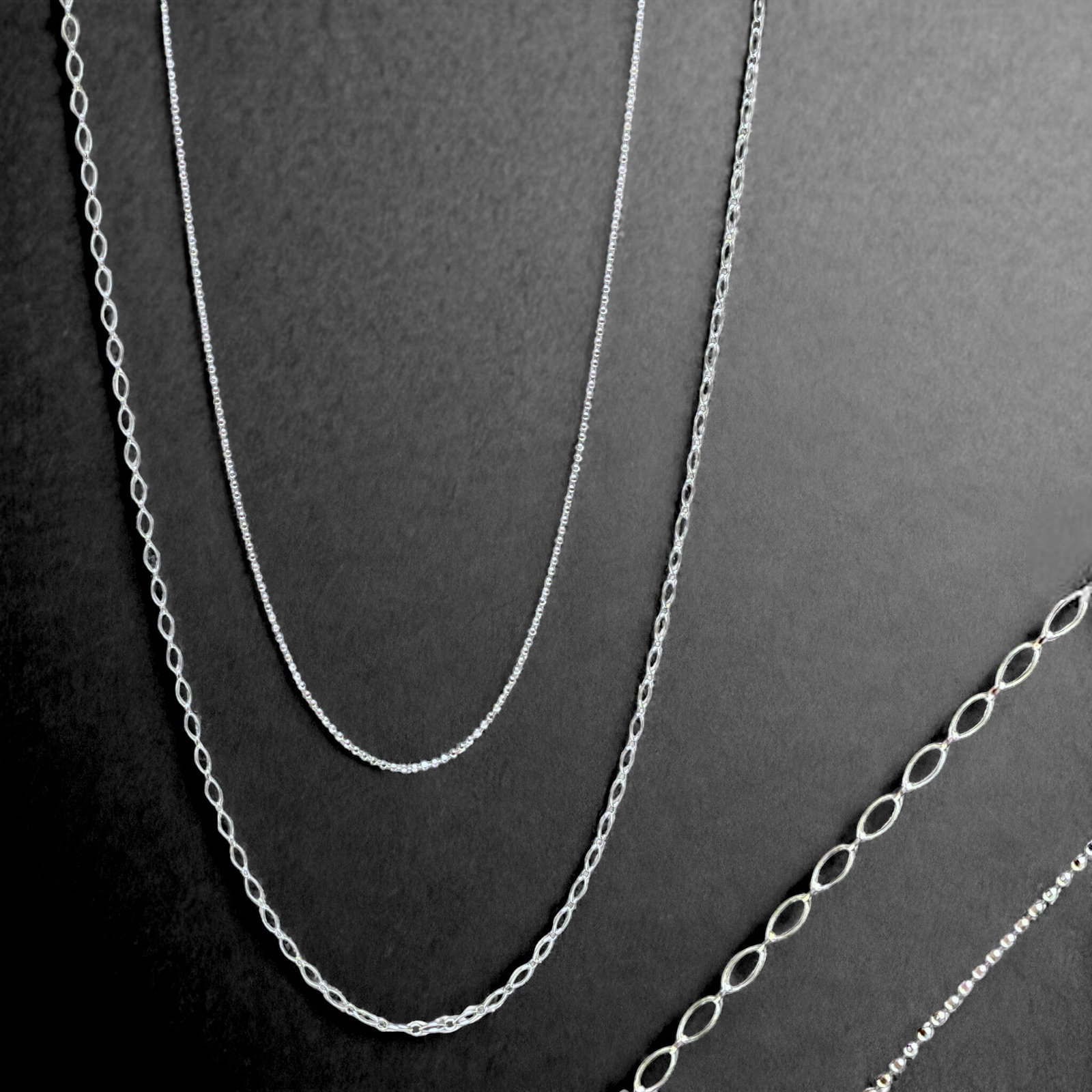 Chic Sterling Silver Chain Duo: Elevate your accessory game with this chic collection of sterling silver chains. The Diamond Cut Bead Chain, measuring 18" with a 3" extension, adds a touch of sparkle and texture to your neckline. Me
