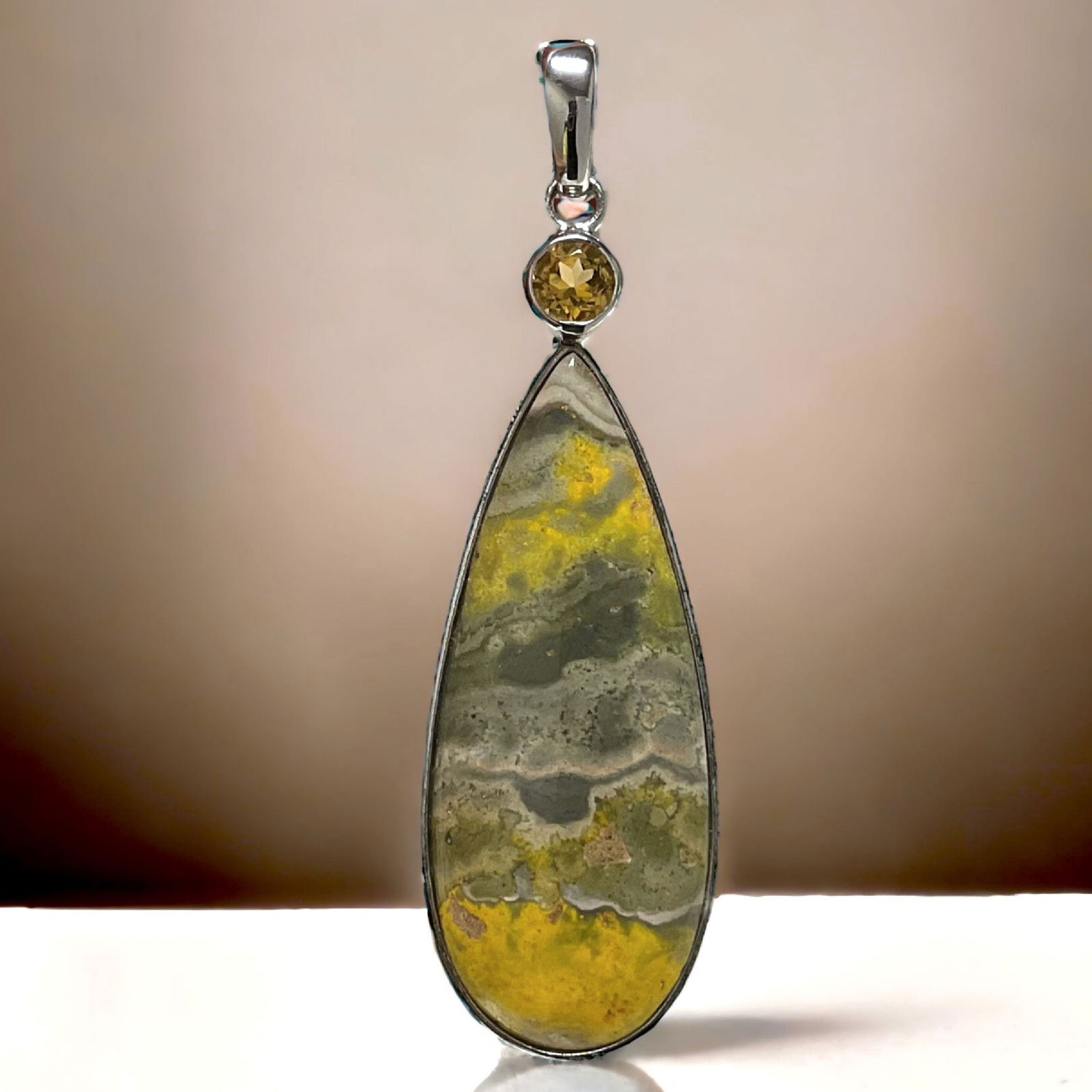 Sun-Kissed Bumble Bee Jasper & Citrine Pendant: This sterling silver pendant features a captivating Bumble Bee Jasper cabochon, showcasing its unique and vibrant patterns. The warm tones of the stone are perfectly complemented by the sparkling citr
