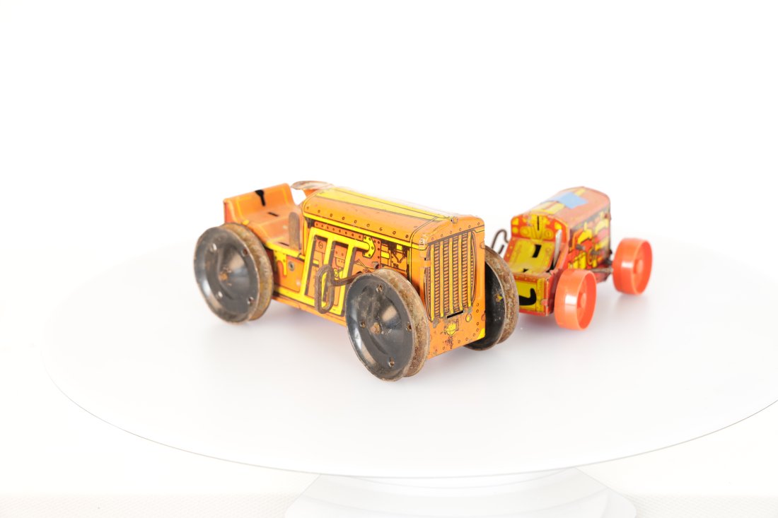 Louis Marx & Company Toy Antique Tin Toy Tractors Set: Step back in time with this charming set of two vintage tin toy tractors. These delightful collectibles are a nostalgic reminder of the simpler days of play. Made with vibrant colors and intricate det