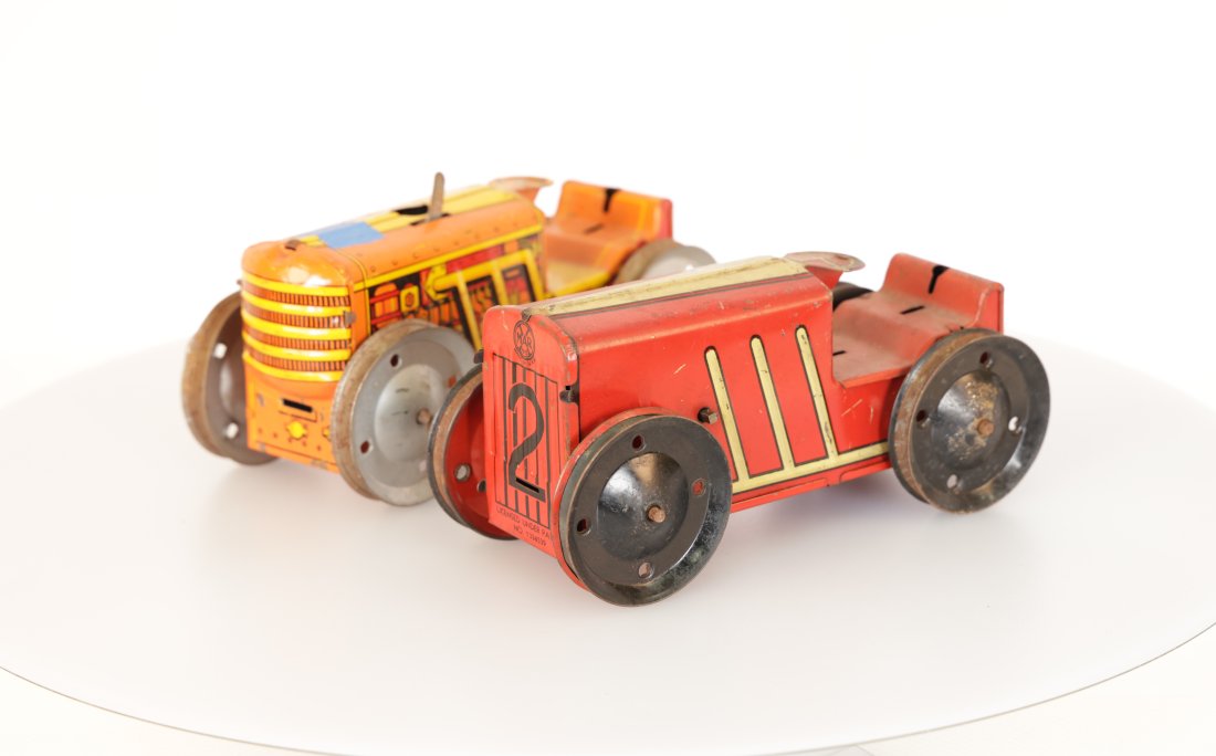 Louis Marx & Company Vintage Tin Wind-Up Tractors - Set of Two: Step back in time with this delightful set of two vintage tin wind-up tractors. A charming addition to any collection, these brightly colored toys bring a touch of nostalgia and a glimpse into the pla
