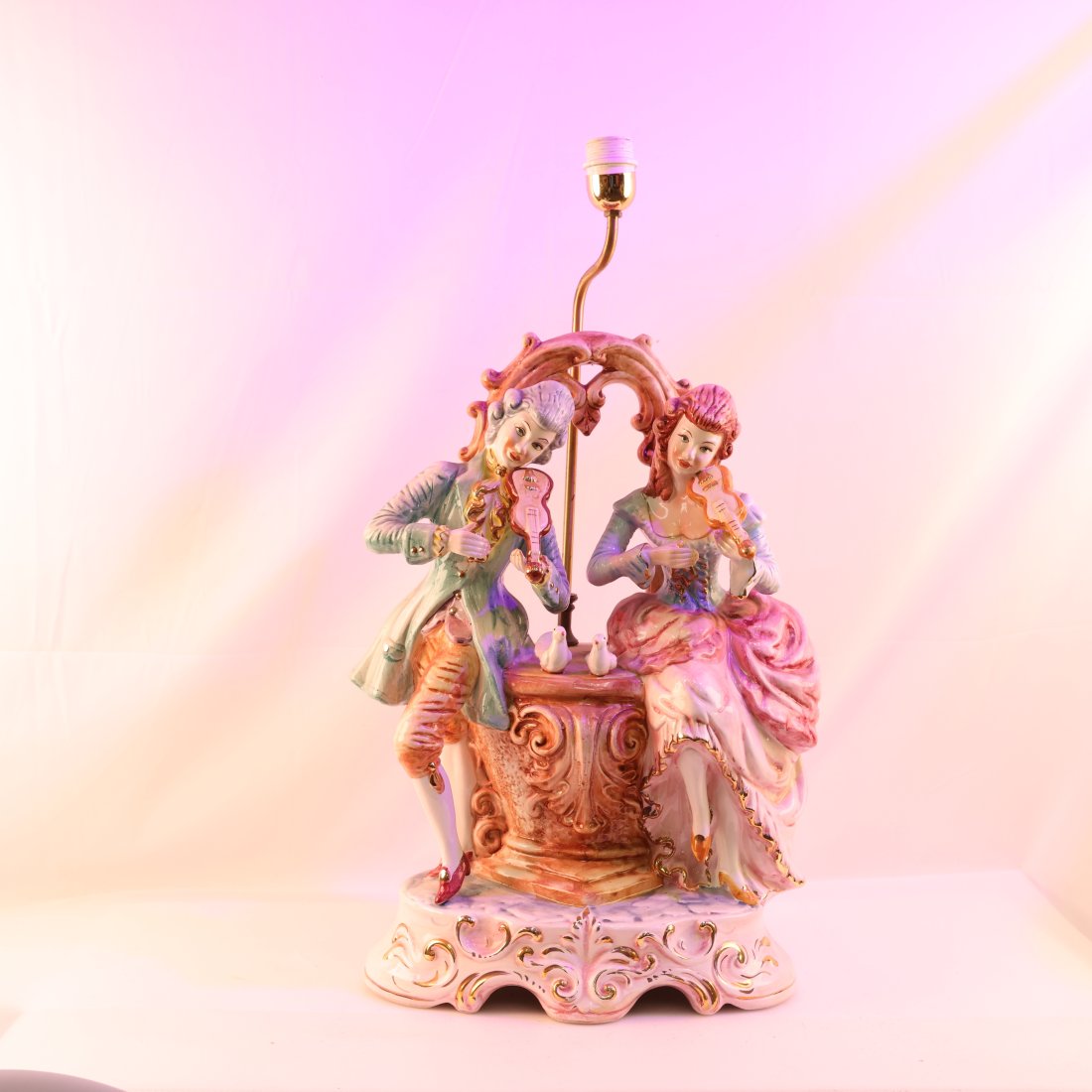 Exquisite Capodimonte Porcelain Figurine Lamp: Add a touch of classic elegance to your home with this stunning Capodimonte porcelain figurine lamp. Expertly crafted in Italy, this lamp features a charming scene of two musicians, dressed in intrica
