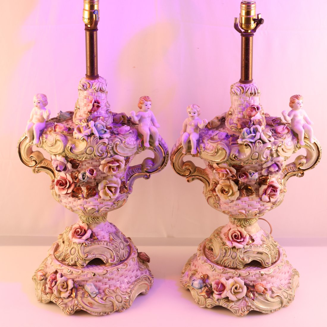 Pair of Vintage Capodimonte Cherub Table Lamps: Elevate your home decor with this enchanting pair of vintage Capodimonte table lamps, adorned with charming cherubs and delicate floral details. These exquisite lamps are a stunning example of the fin