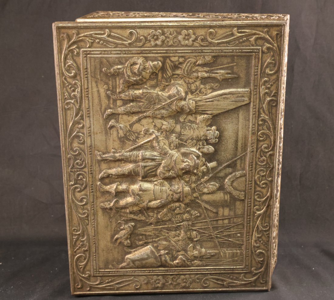 Antique Embossed Metal Box with Historic Scene: This exquisite antique metal box features an intricately embossed depiction of a historic scene, showcasing remarkable craftsmanship and attention to detail. The raised relief artwork on the lid captu