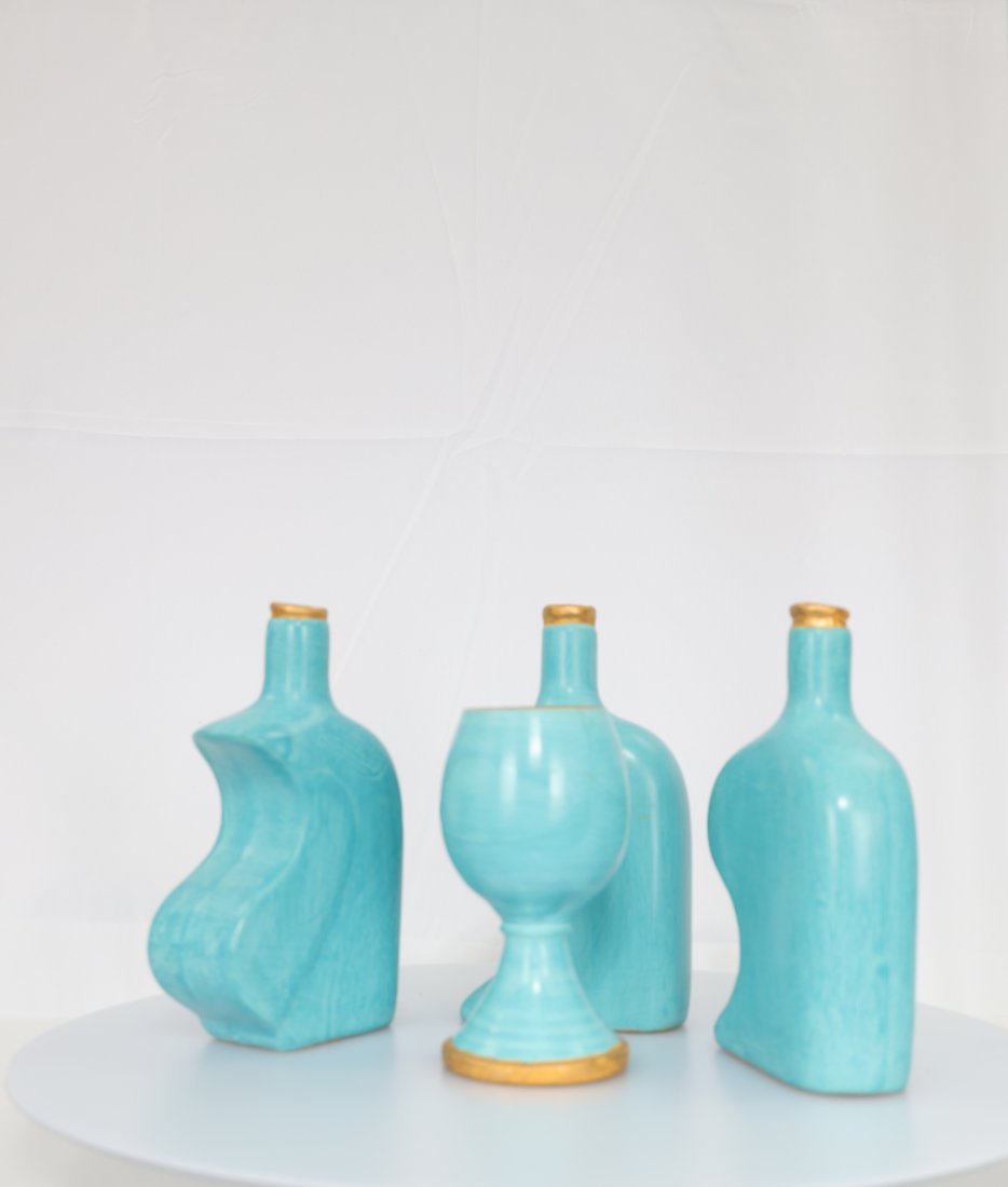 Exquisite Turquoise Ceramic Decanter Set with Gilded Accents: Add a touch of elegance and sophistication to your home decor with this stunning turquoise ceramic decanter set. This unique set includes three decanters and one goblet, each crafted with a distinct s