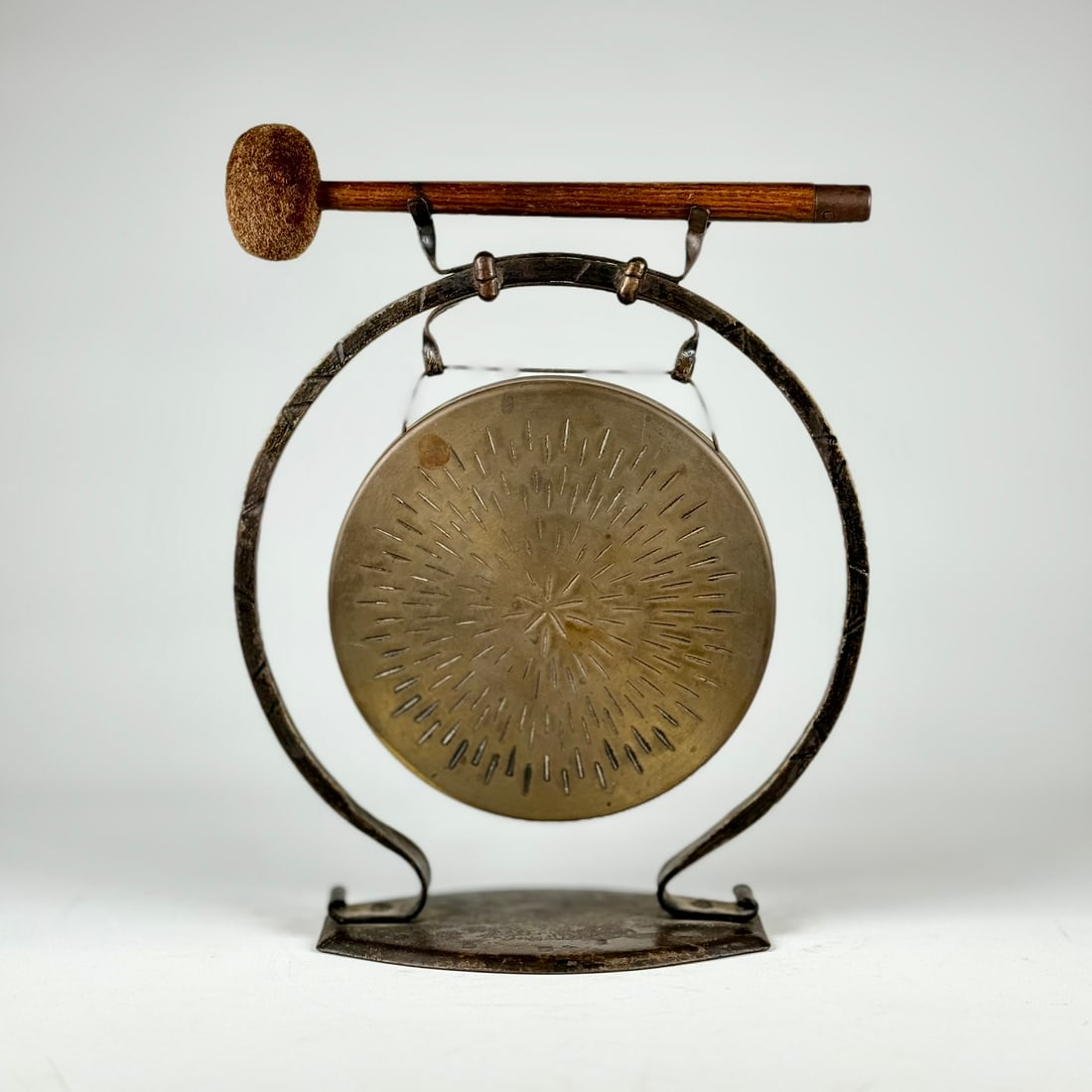 Small Goberg Arts & Crafts Wrought Iron Gong: Hugo Berger wrought iron arts and crafts table-top dinner gong with original oak and mohair striker. Marked under base with impressed "GOBERG" shop mark. Circa 1910. Germany. 10"h x 8"w x 3.5"d. Gong