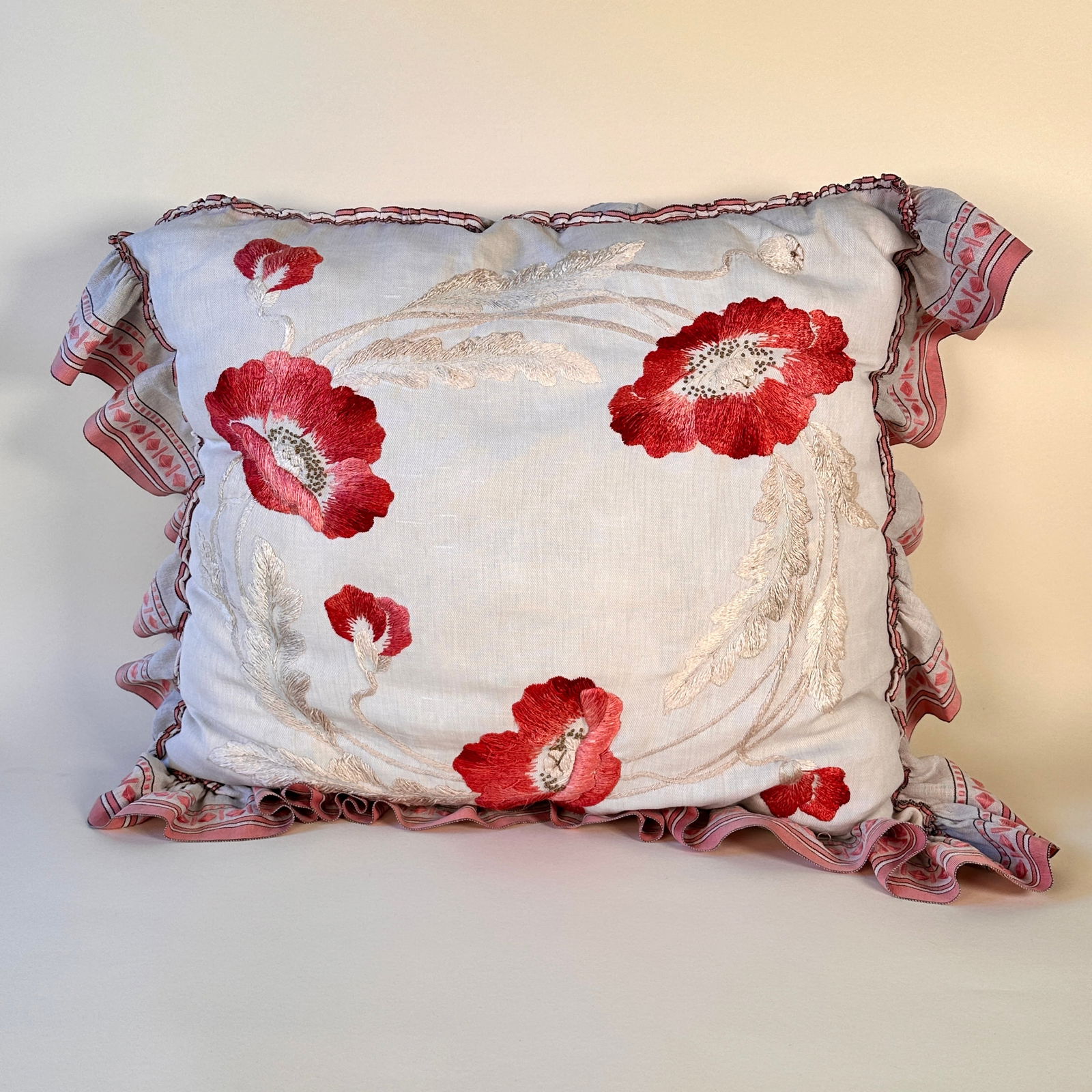 Arts & Crafts Poppy Embroidered Pillow: Arts & Crafts poppy pillow circa 1905. A nice embroidered pillow with a swirling poppy design in reds, pinks and creams. The edge is finished with a wide linen featuring embroidered geometric designs