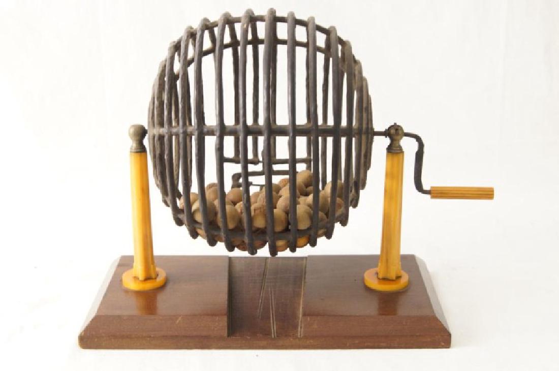 Antique lottery wheel with orig. wood carved balls: Antique lottery wheel with original wood carved balls Bakelite standing columns and turning lever coated steel cage bronze opening measures 16" x 8" x 12"