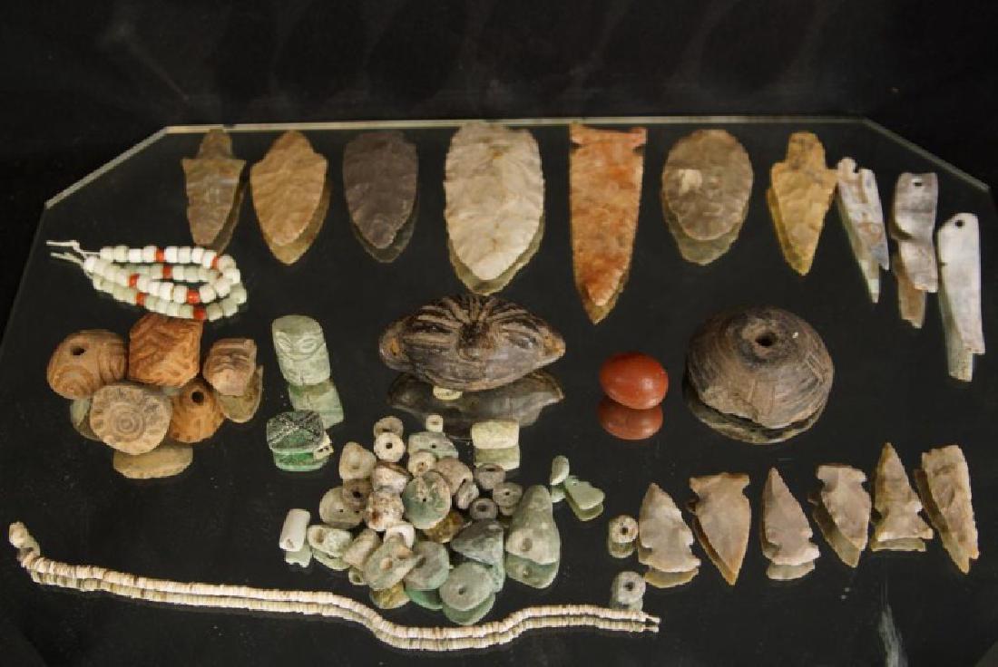 Pre Colombian Arrowheads, beads, buttons, tools: 13 Stone carved spear and arrowhead points measuring from 4.5" to 1.5" a number of stone carved beads, ceramic beads, a seashell bracelet, and a ceramic North Mexico effigie of a head, 3 abalone shell