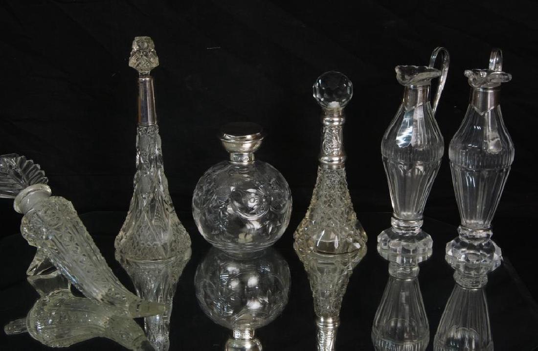 Six Antique Crystal and sterling vessels: An early English Silver hallmarked etched crystal bottle with sterling top, a pair of etched crystal condiments, two antique silver perfumes with silver, one hallmarked with old English marks and a cr