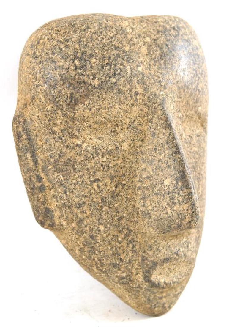 A Mayan great stone mask of elongated form: A Mayan great carved stone mask of elongated form with prominent long nose blending into over sunk eyes and lips, a vision of Mayan rank. High born Mayans wore a head press to achieve a flattened fore