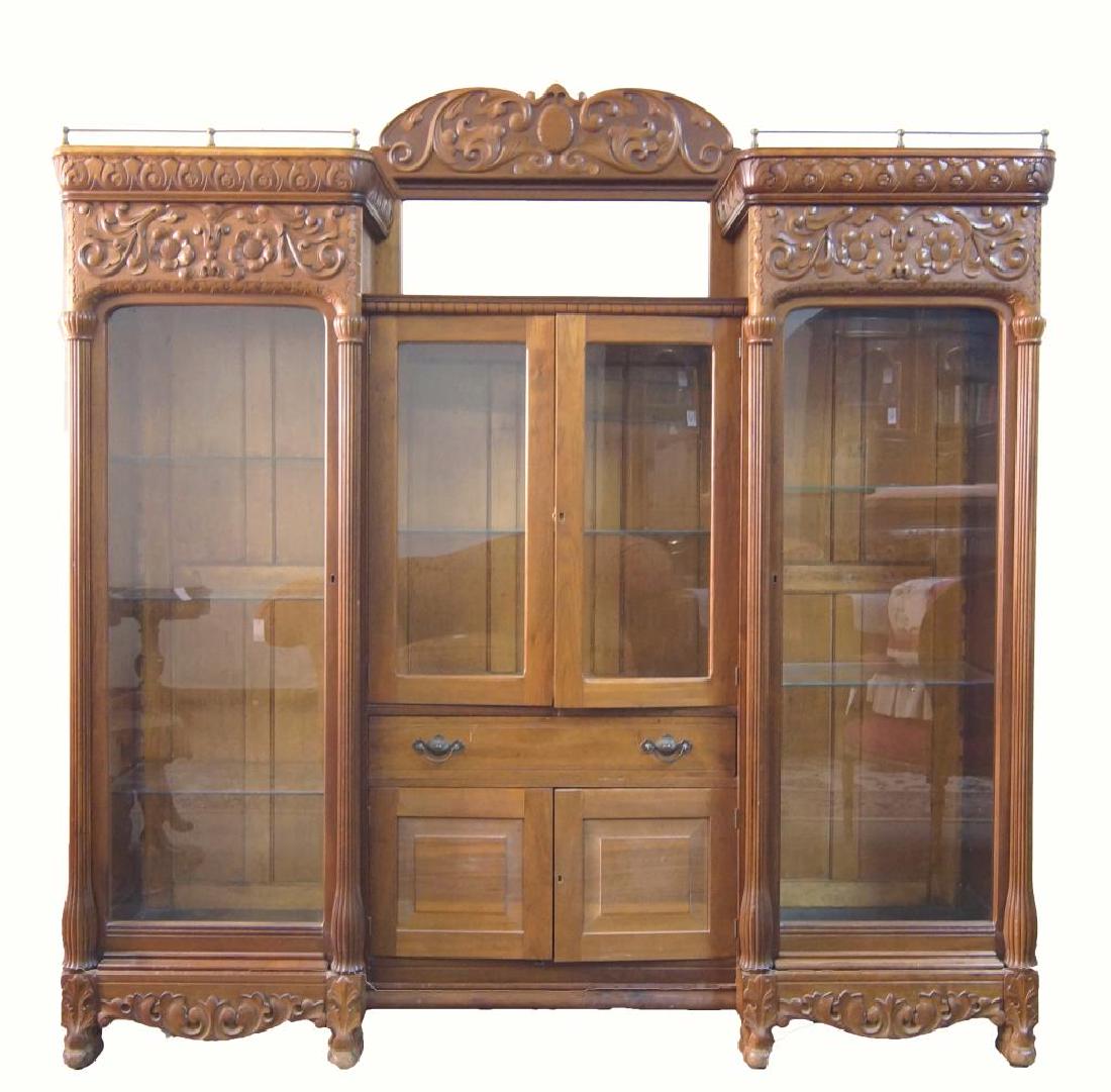 Antique American Mahogany double bookcase china: nicely carved long china cabinet sides framed with elongated columns and topped with brass galleries, a central beveled mirror under a carving and two addition central locking doors atop a drawer and 