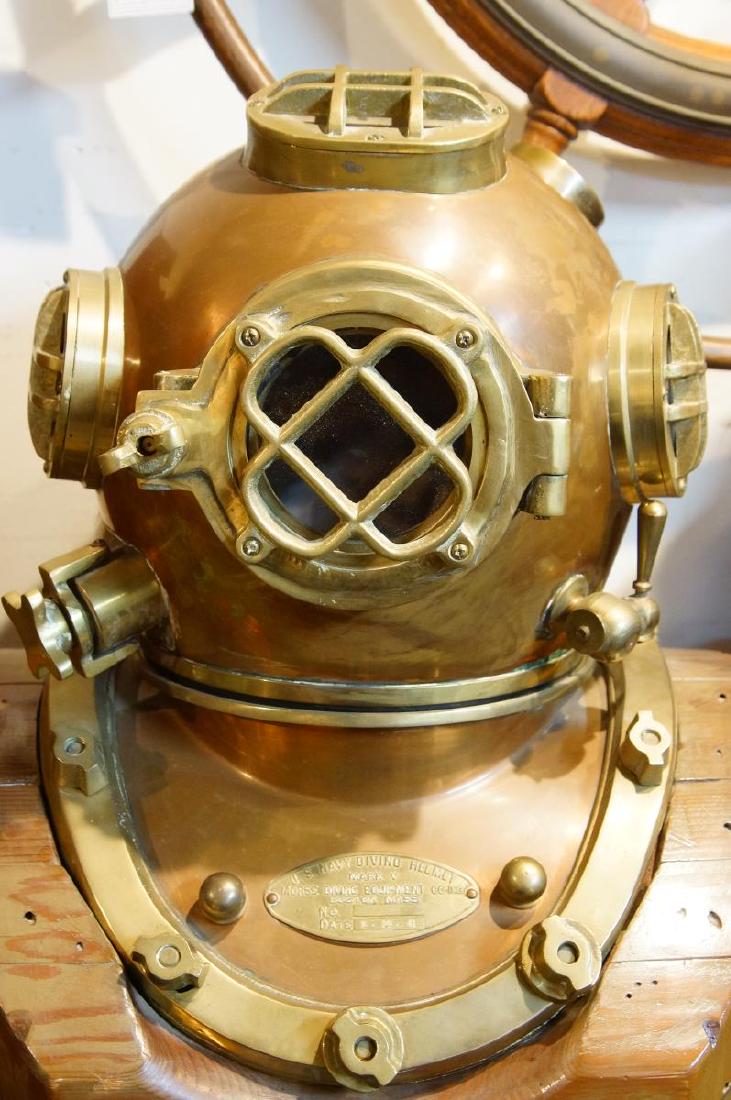U.S. Navy brass Diving Helmet with Custom Stand: Nice brass and copper construction, large in and out air ways and hoses with large working lugs. Includes wood carved nest and display stand. Plaque reads U.S. Navy Diving Helmet Mark V Morse Diving E