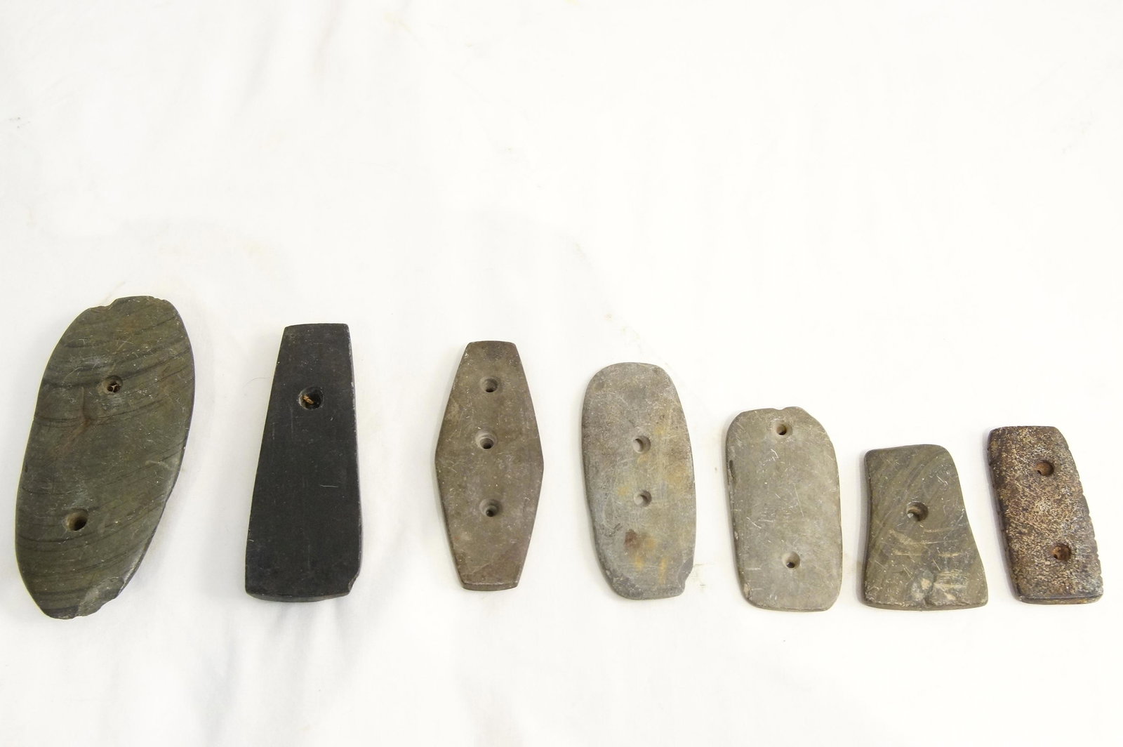 Prehistoric Native American stone drilled gorgets: Gorgets with holes drilled for suspension - The largest 5 1/4" x 2 1/2" and resembles the example used by the University of Iowa from their collection that has similar curved striations, two one-holed