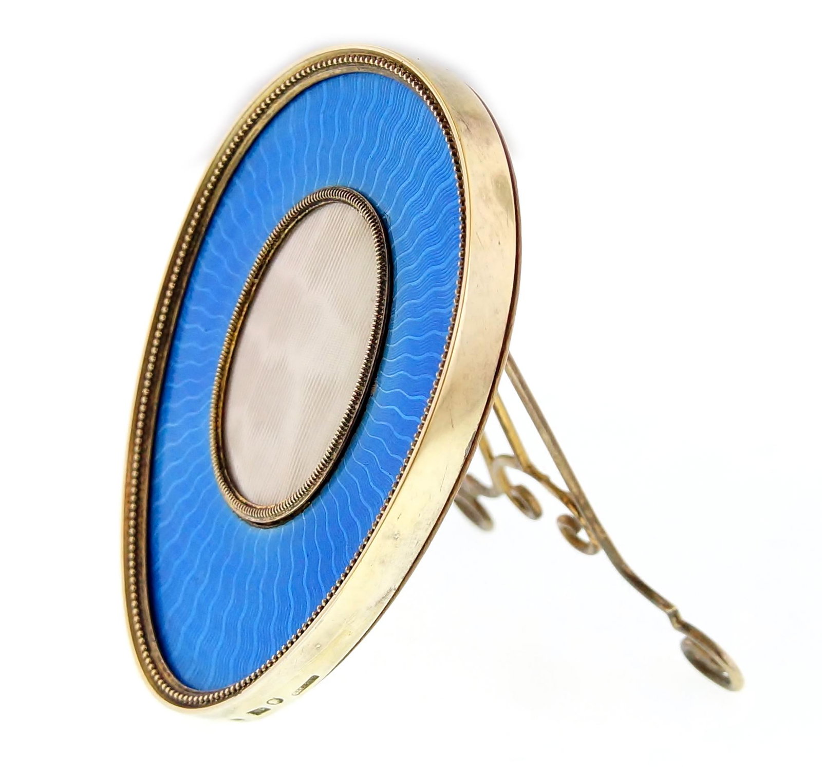 Wilhelm Reimer for Fabergé Enamel and Gilt Frame: Fine light blue to dark enamel with wavy lines frames the inner over. Gilded Silver, wood back and glass construction. The 70 x 60 x 9 mm egg shaped frame is marked on the frame 84, WR, Russian Face (