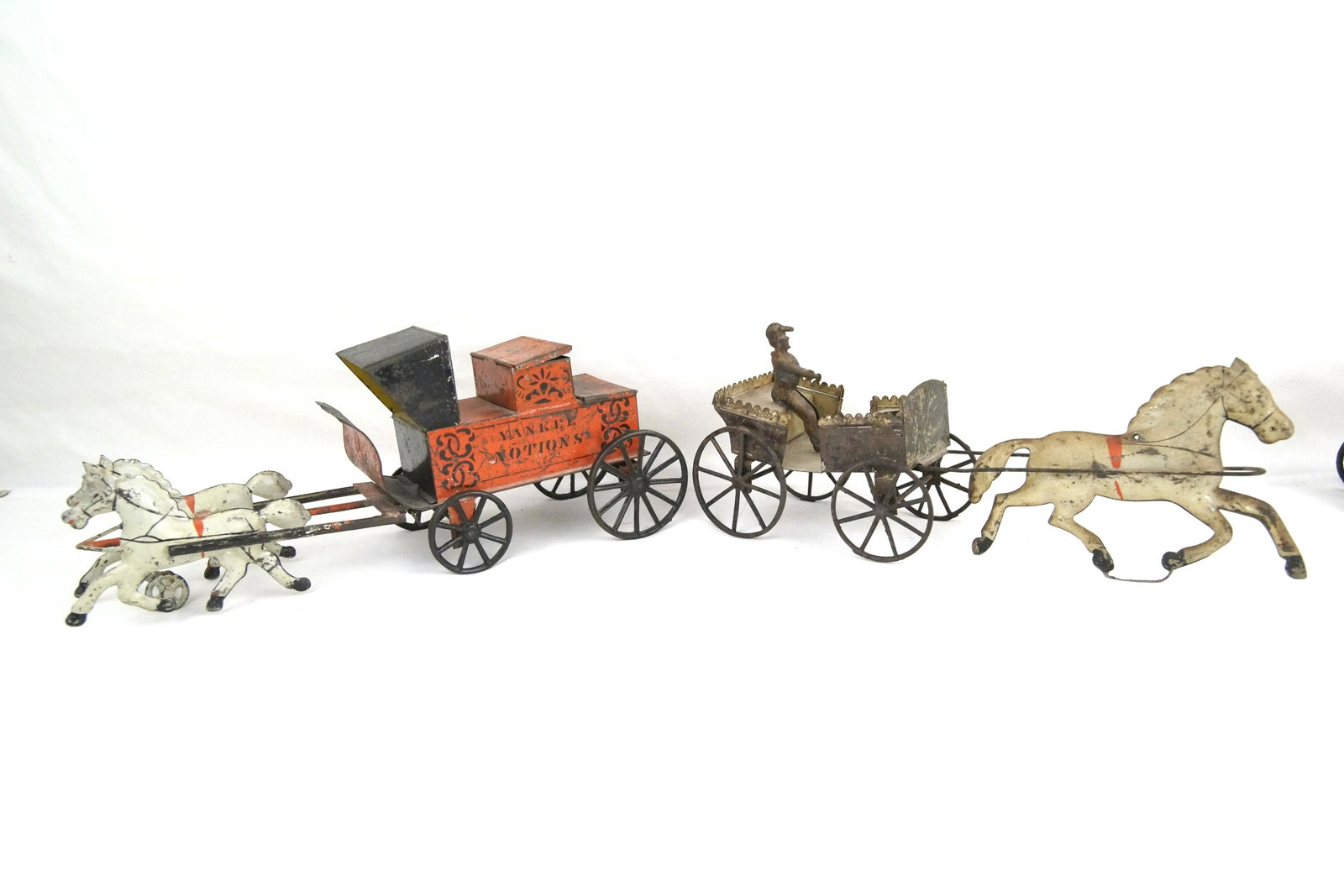 Two antique Tin Wagon Toys Yankee Notions & wagon: Yankee Notions measures approx 11" and the other pull cart measures approx 11" Both show age and wear, one has an old repair, both in good condition