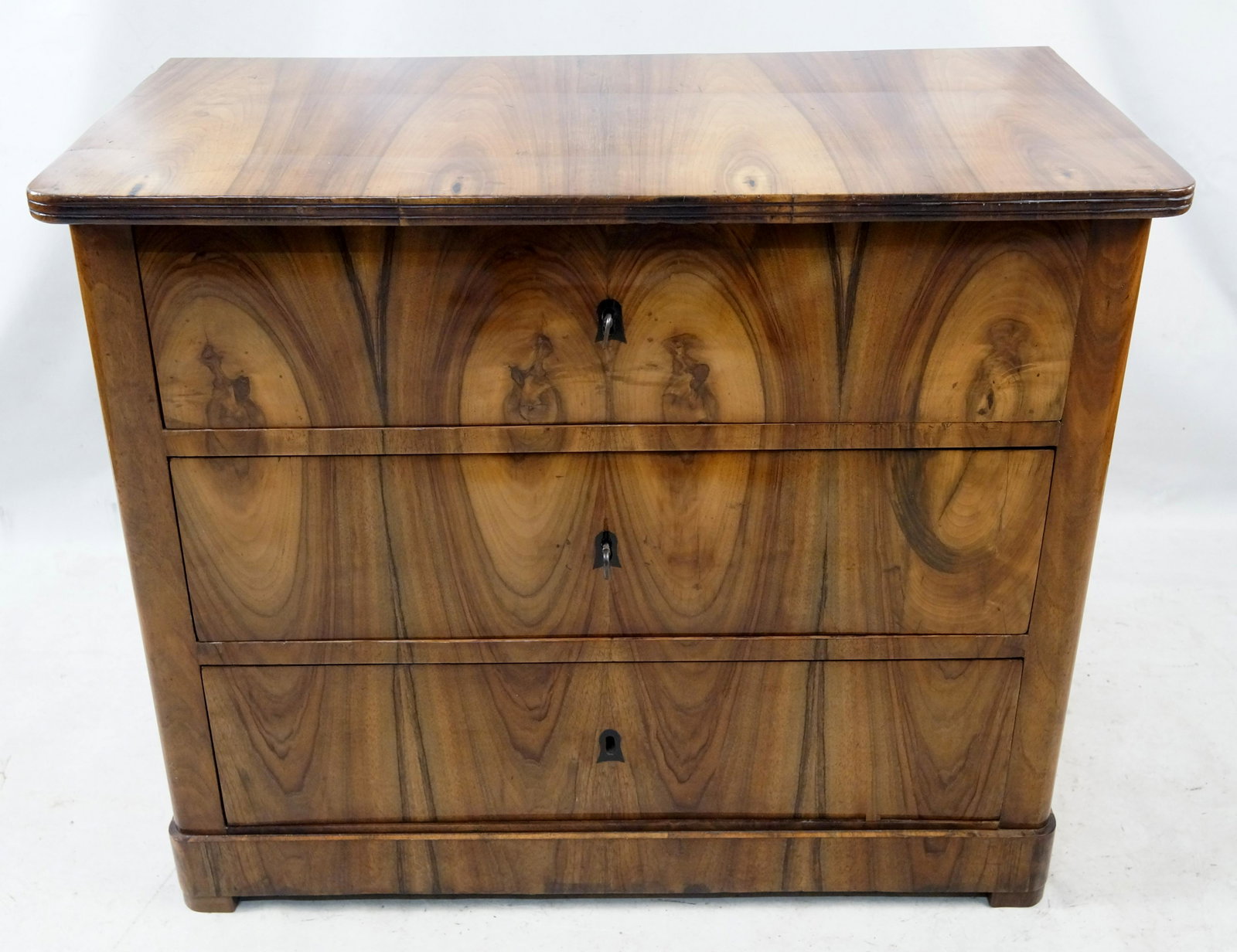 German Biedermeier Chest of Drawer circa 1825: Biedermeier Chest of Drawers, Germany c. 1825 Highly figured and book matched Burl veneer with ebonized key escutcheons, restored finish, 30 x 36 x 18in