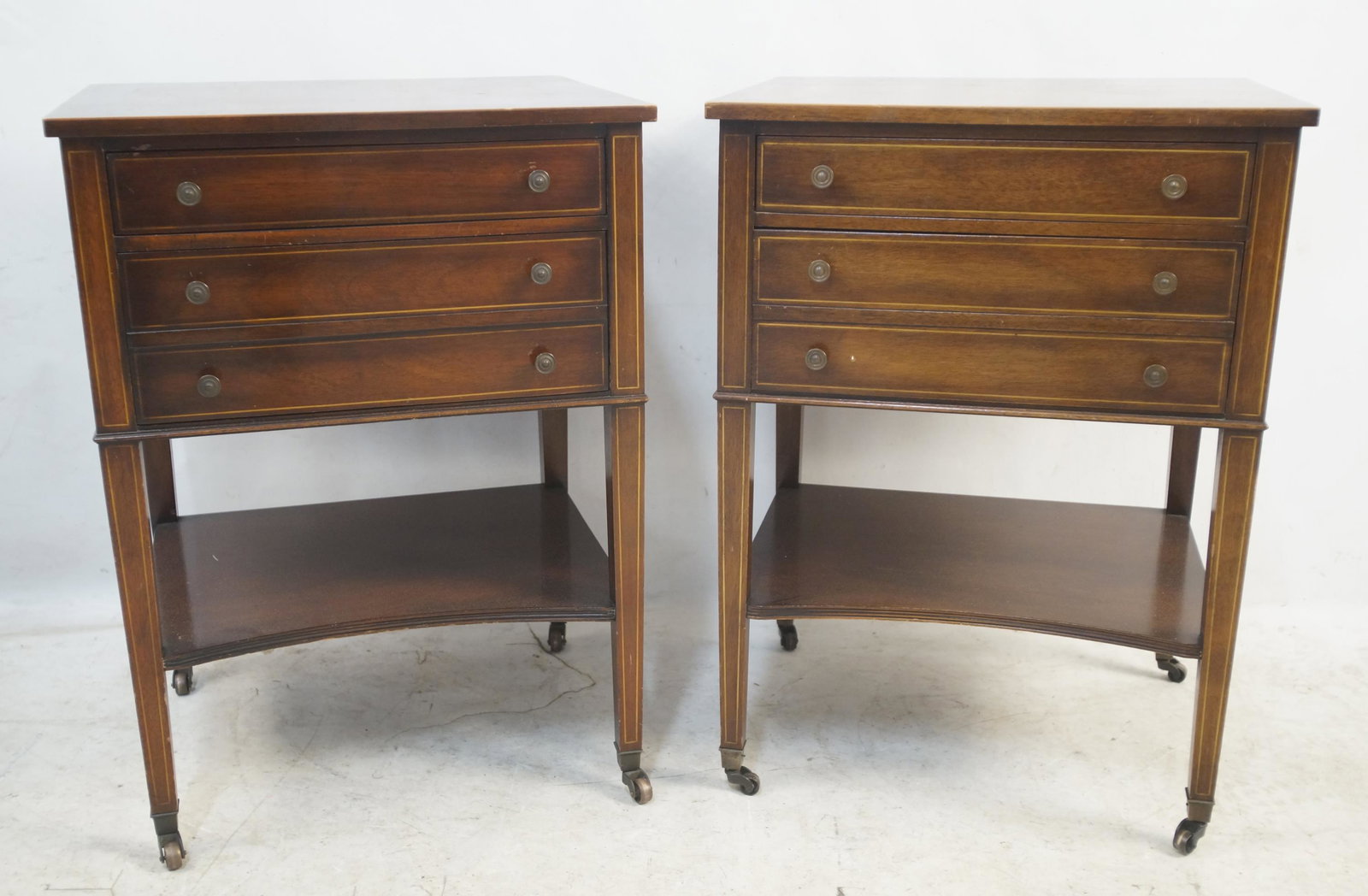 Pair of Antique Sheraton Style Nightstands: Mahogany - Three drawers with tapered legs and brass wheels